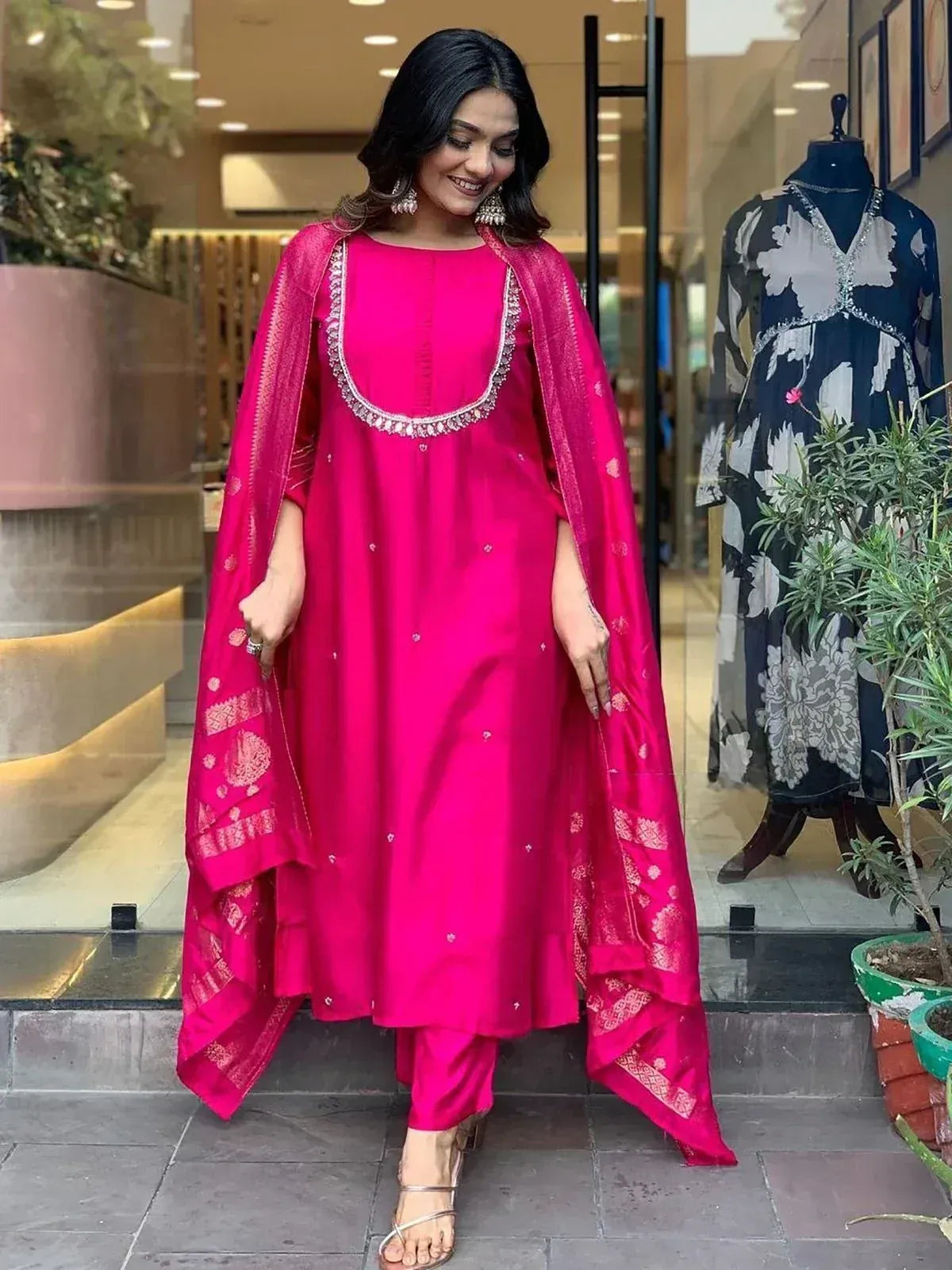Vibrant pink Indian salwar kameez with embroidered neckline and matching dupatta, styled for festive occasions.