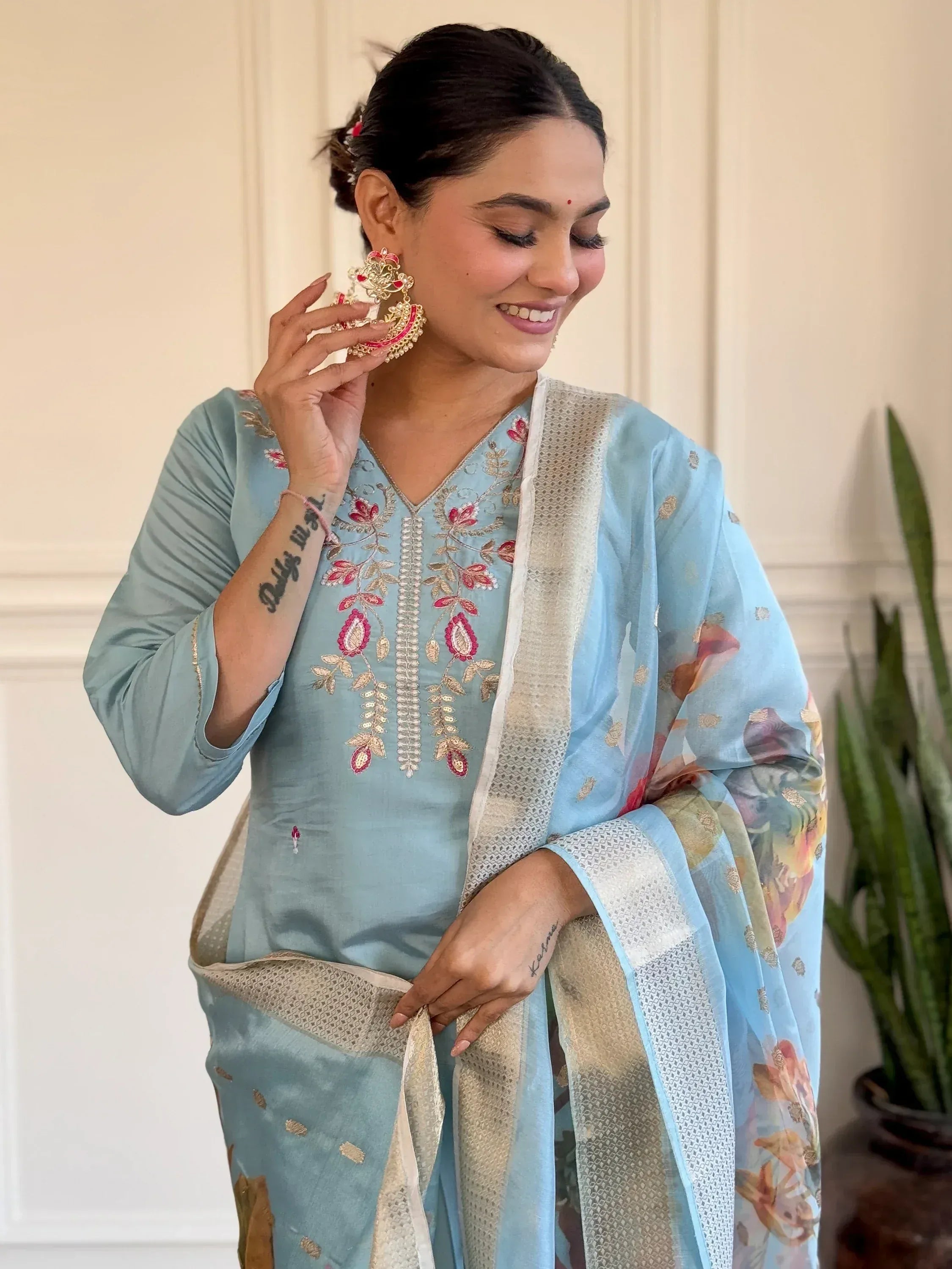 Woman in light blue embroidered salwar kameez with floral dupatta, traditional Indian ethnic wear