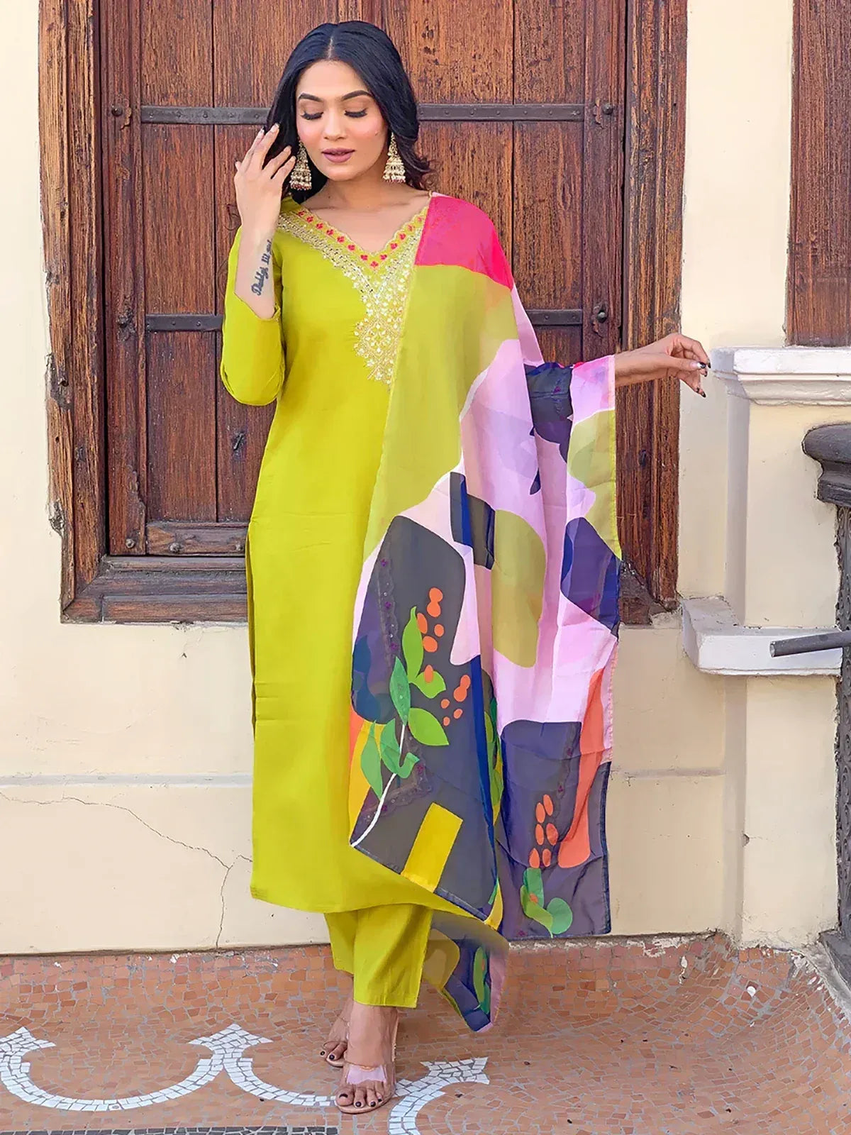 Vibrant green salwar kameez with embroidered neckline and colorful abstract dupatta, perfect for ethnic wear.