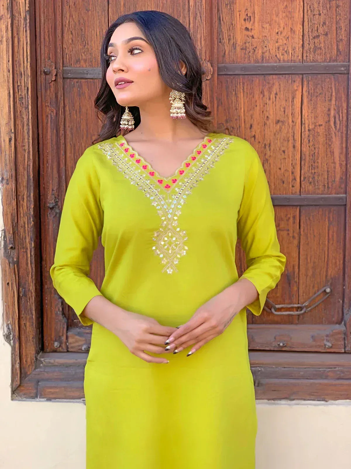 Lime green ethnic kurti with pink and gold embroidery, paired with jhumka earrings, perfect for Indian wear.