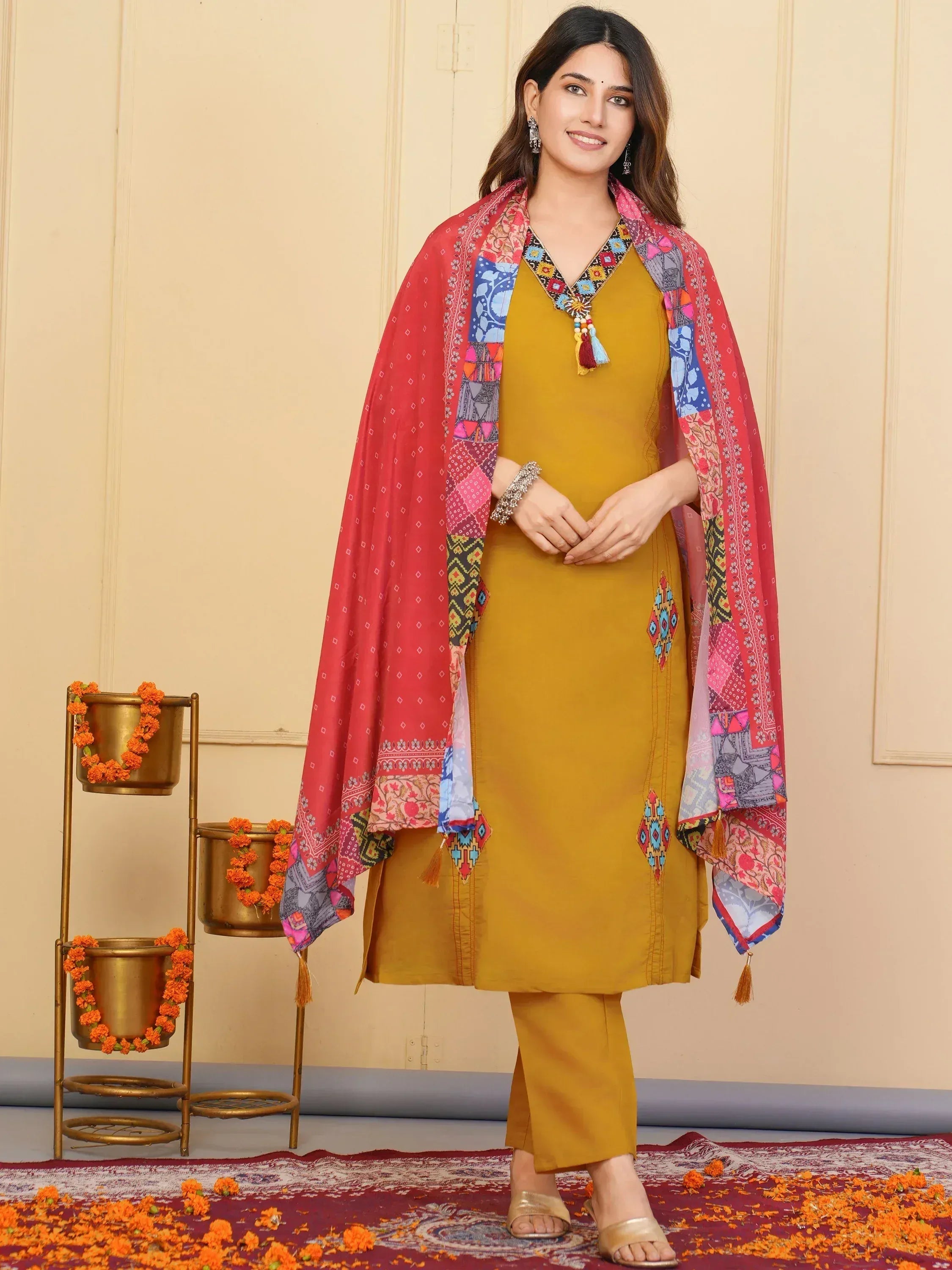 Mustard yellow ethnic kurti with embroidered neckline, paired with matching pants and colorful printed dupatta for festive occasions