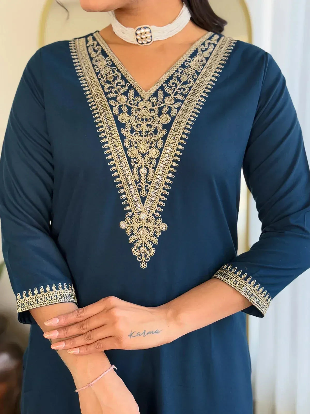 Navy blue ethnic kurti with gold embroidery, V-neck design, and matching sleeve detailing for women.