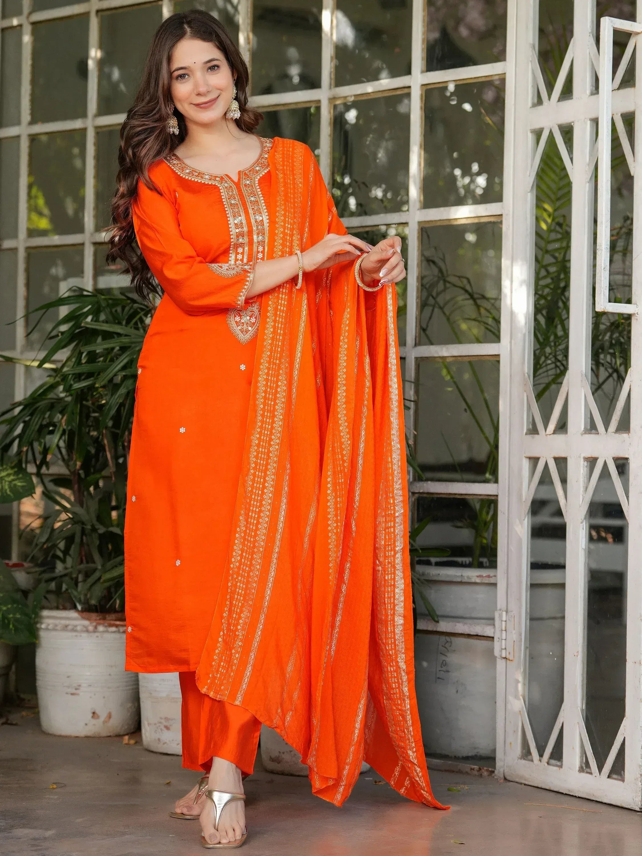 Vibrant orange salwar kameez with gold embroidery, perfect for ethnic occasions and festive wear.