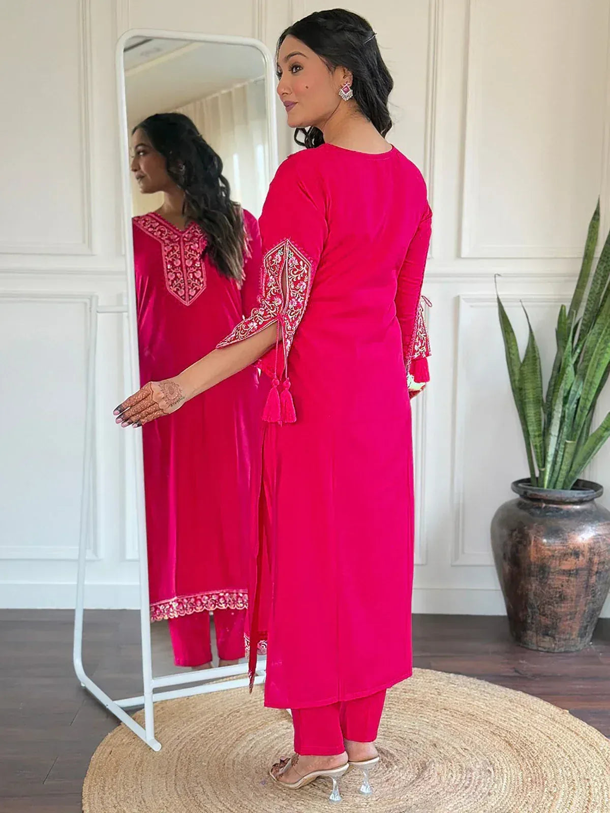 Pink embroidered kurta with tassels and matching pants, styled with mirror reflection and henna hand