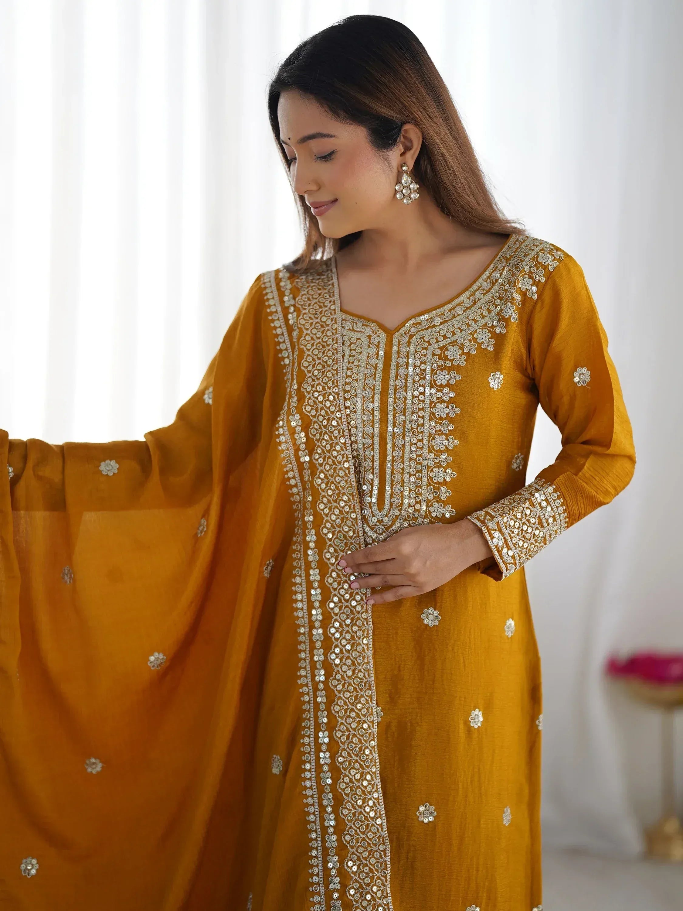 Mustard yellow ethnic kurta with silver embroidery and mirror work, paired with matching dupatta for festive occasions