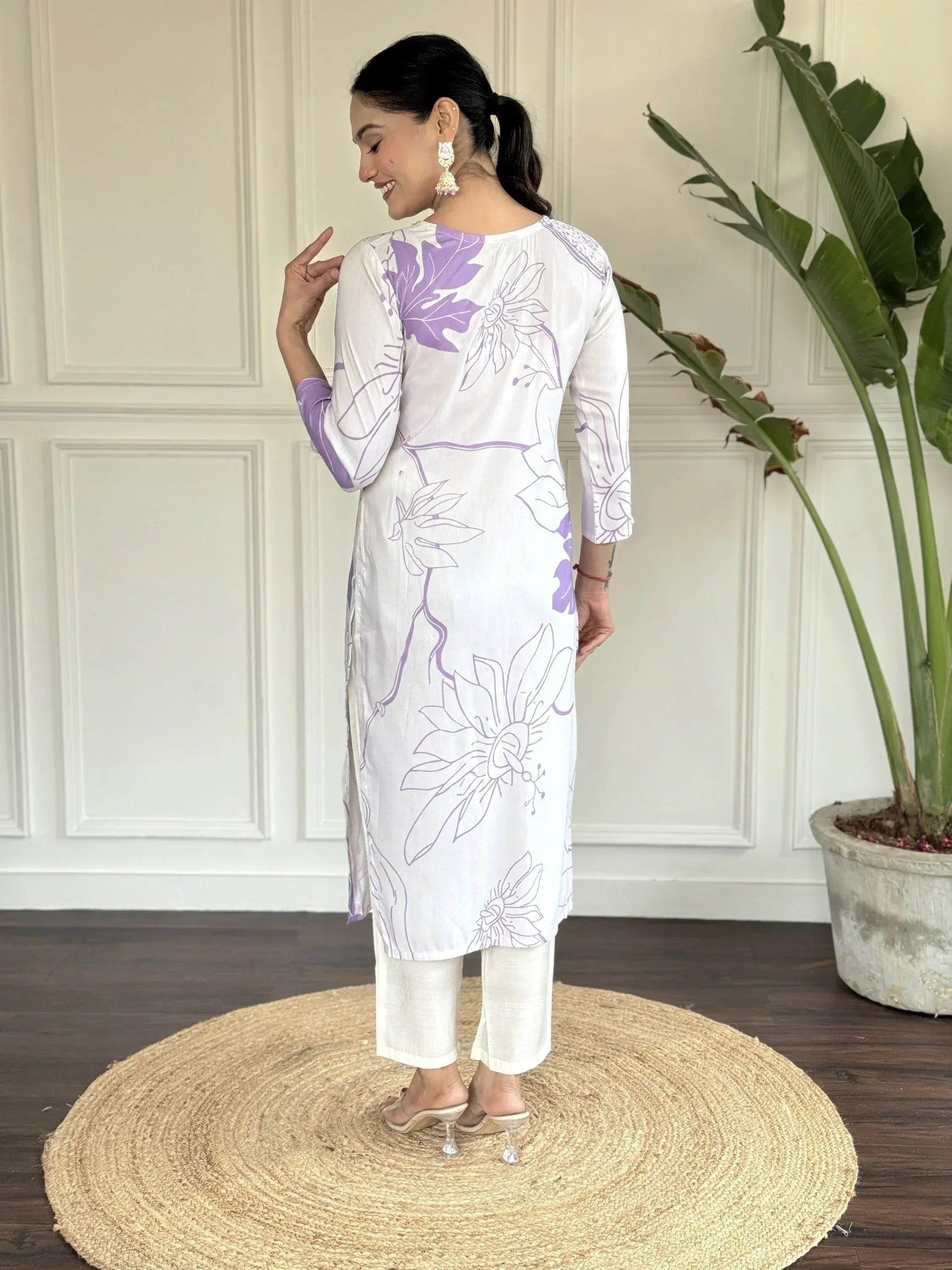 White kurta with purple floral print, paired with white pants, showcasing elegant ethnic wear for women.