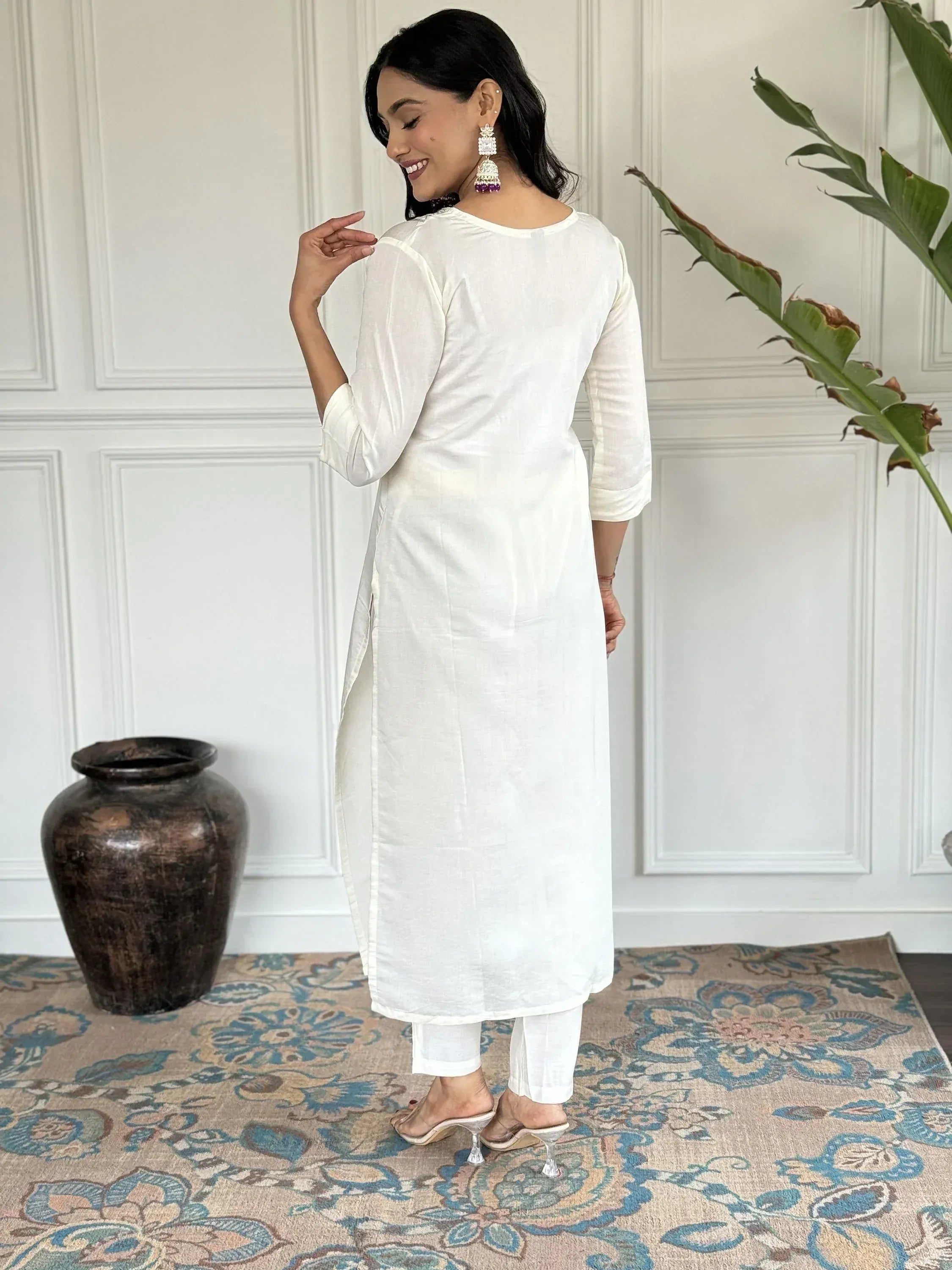 White linen kurta with side slits, paired with matching pants and statement earrings, ideal for ethnic wear.