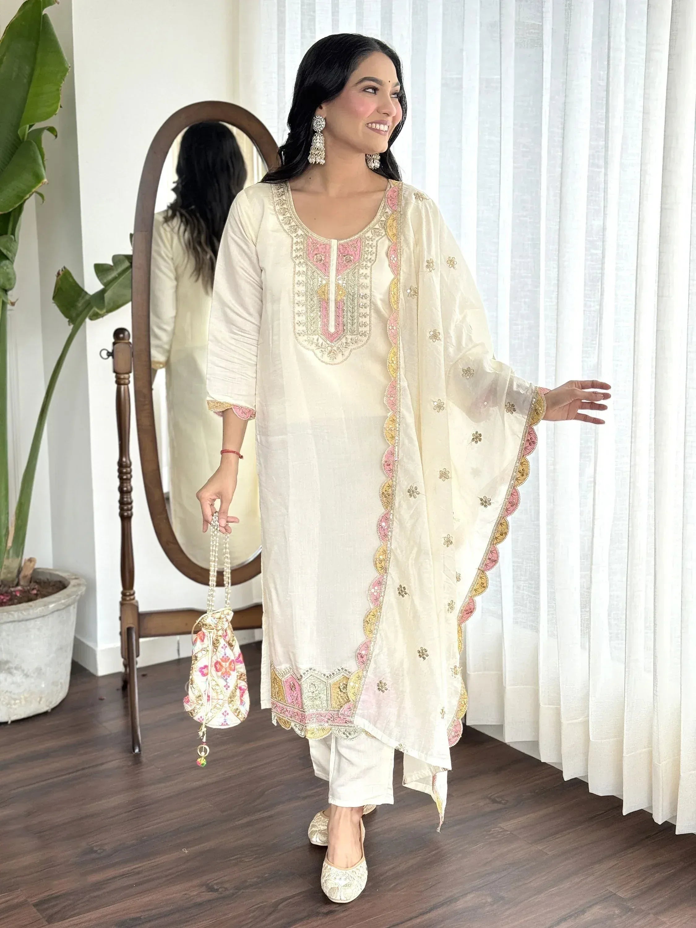 Cream embroidered salwar kameez with pink gold detailing, matching dupatta and floral potli bag