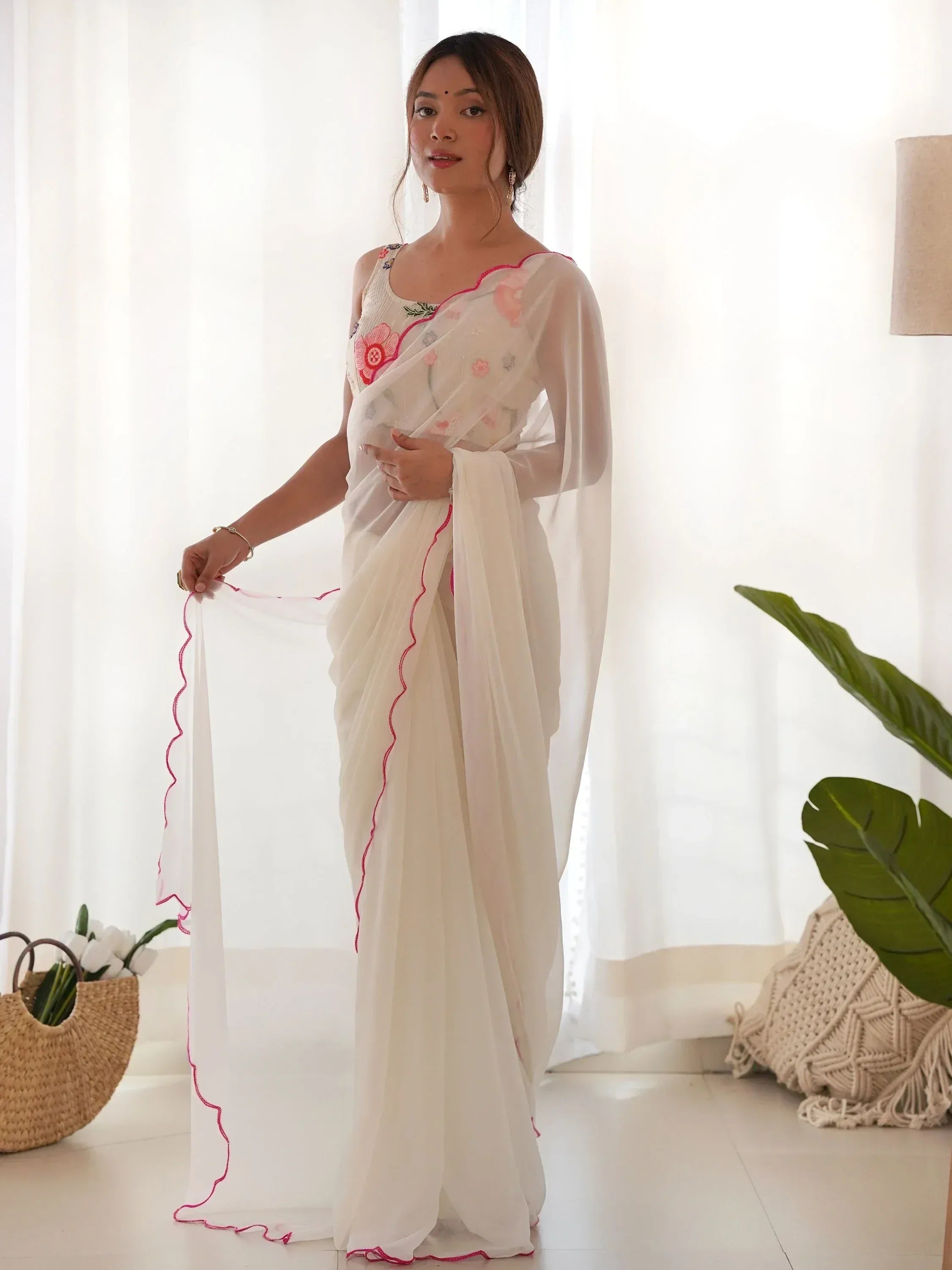 White floral embroidered saree with pink trim, styled with sleeveless blouse for Indian ethnic wear