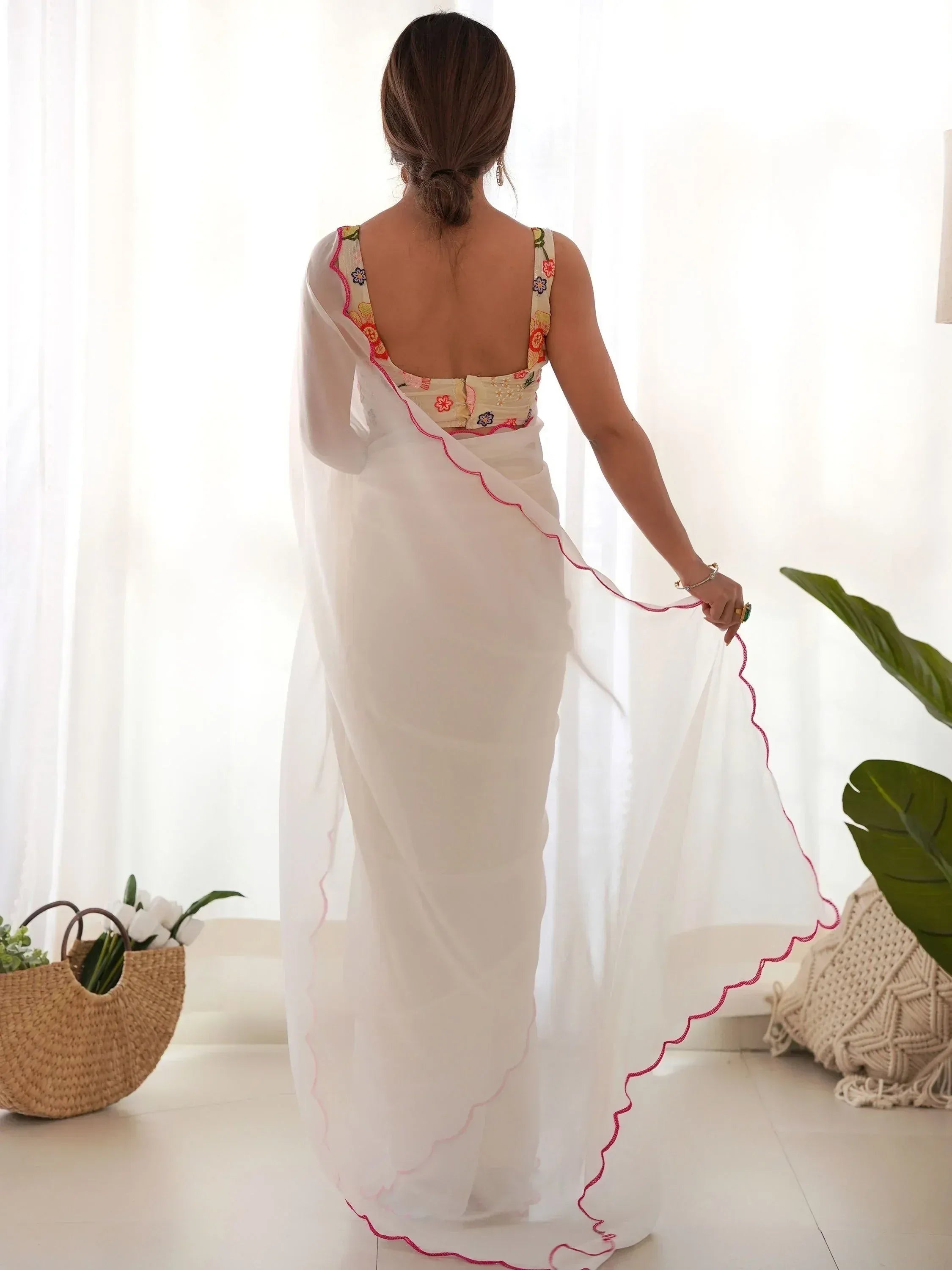 White saree with floral embroidered blouse and pink scalloped border, styled for ethnic wear