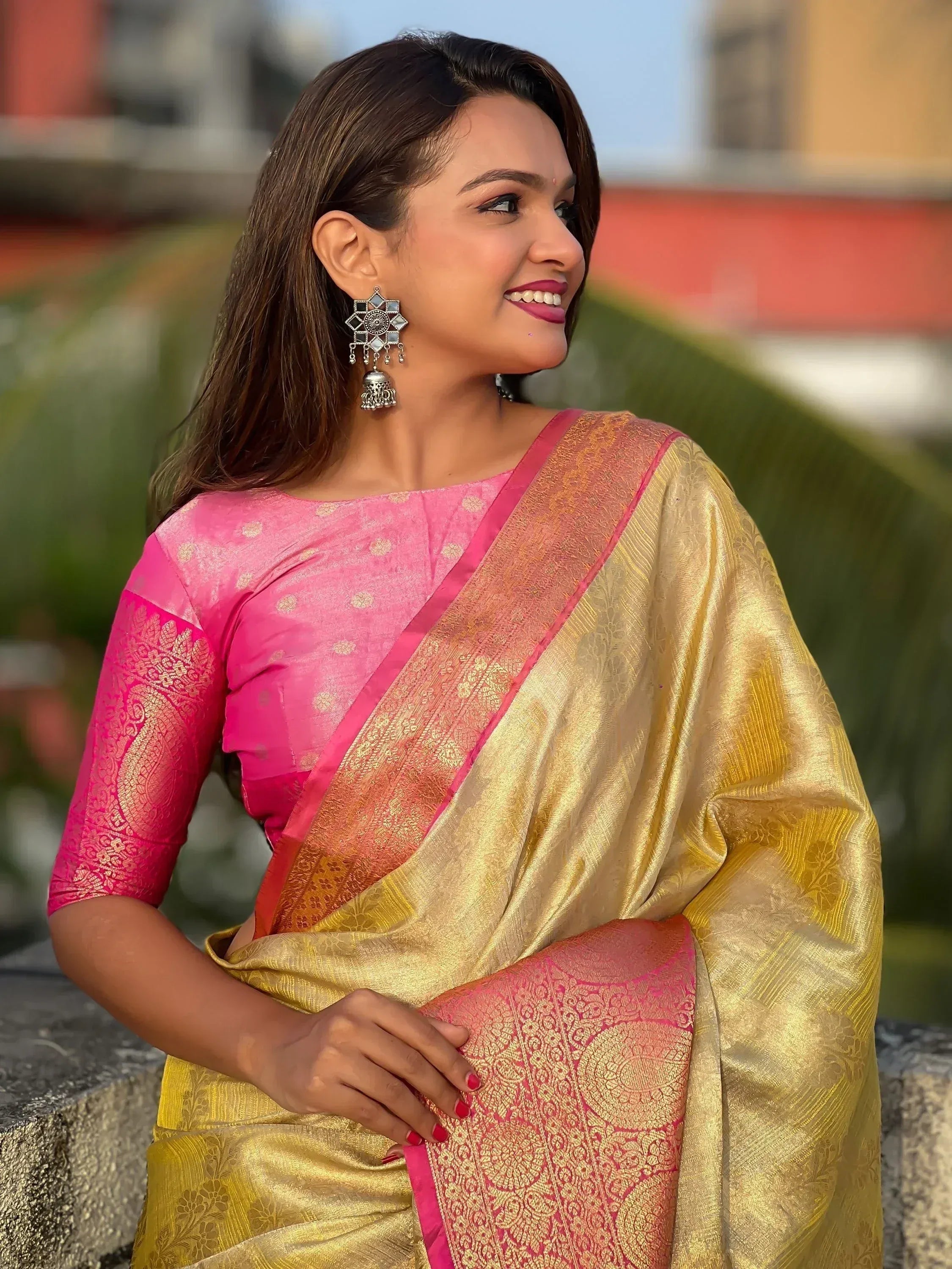 Woman in pink and gold designer saree with intricate embroidery, perfect for Indian ethnic wear occasions