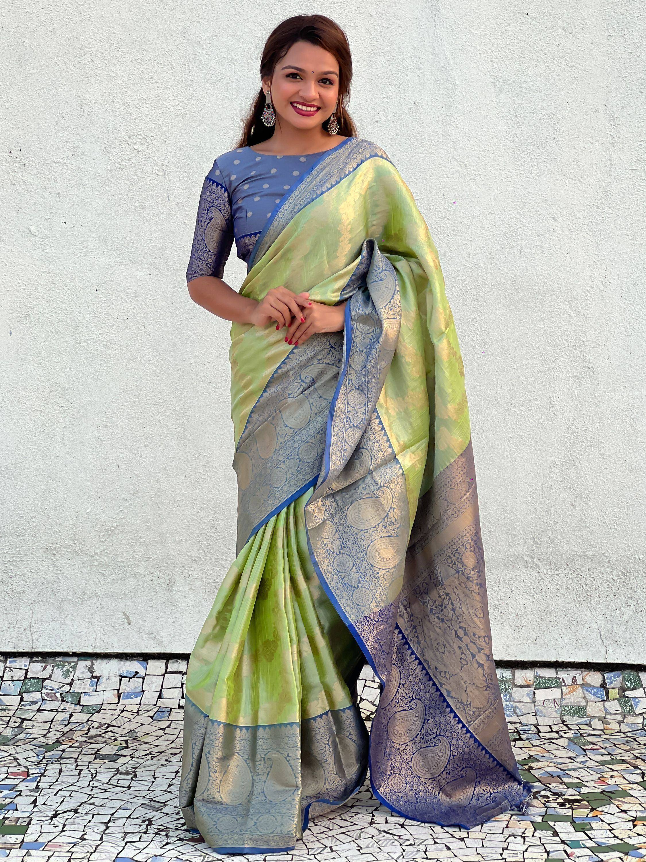 Woman in green and blue designer saree with intricate paisley border, perfect for Indian ethnic wear