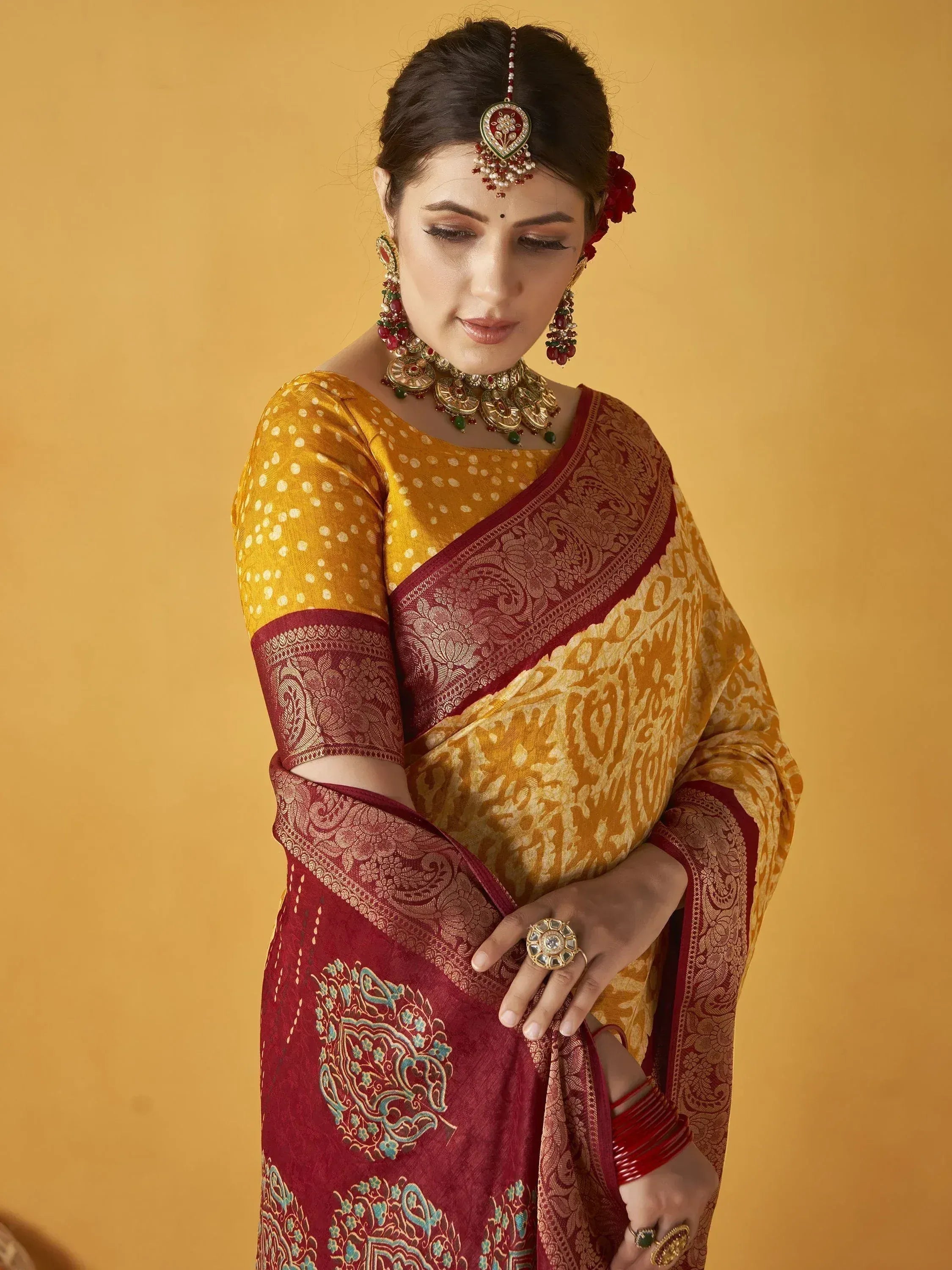 Woman in elegant maroon and gold saree with intricate embroidery, traditional Indian ethnic wear