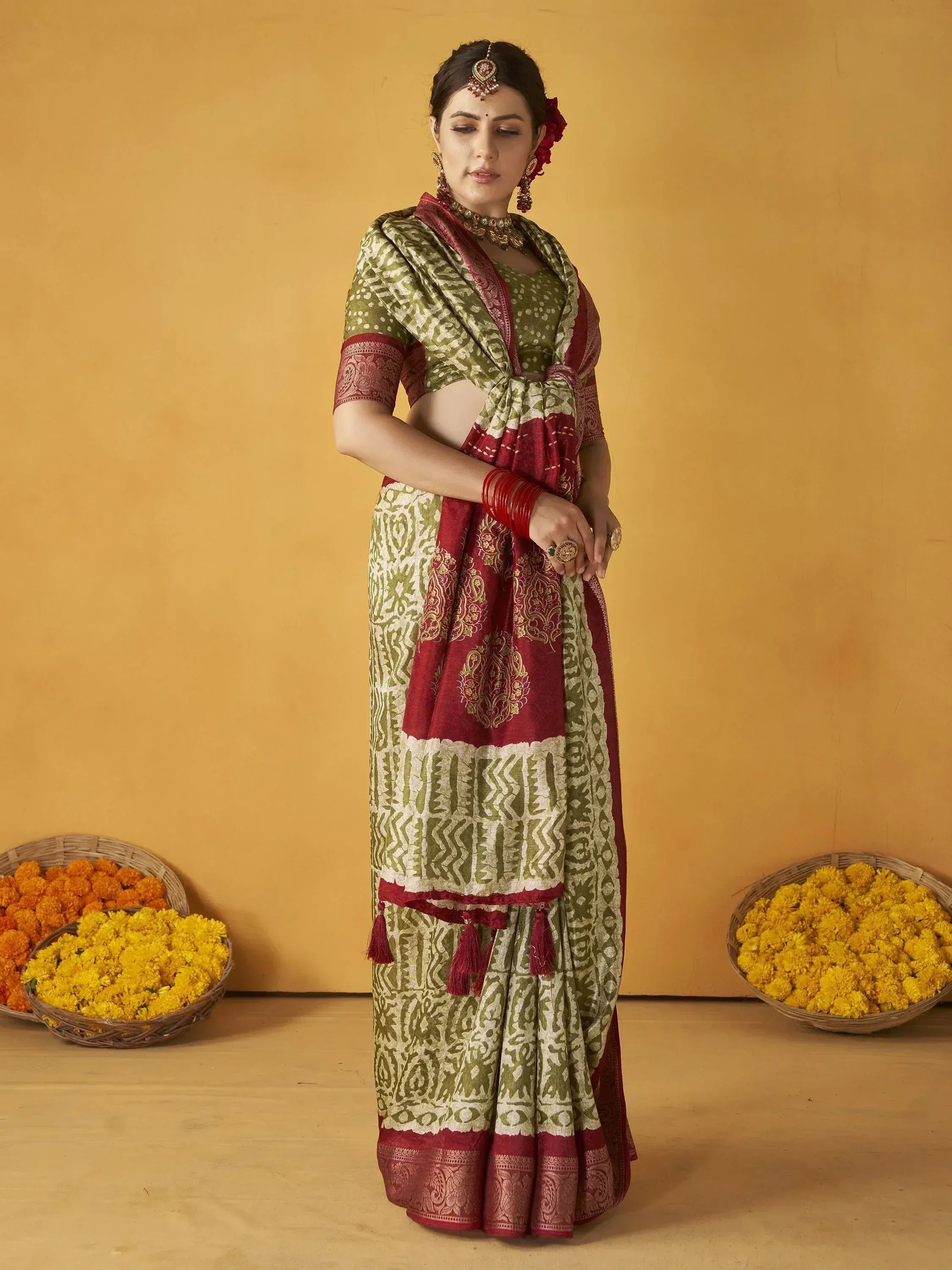Woman in olive green and maroon printed saree with gold embroidery, traditional Indian ethnic wear