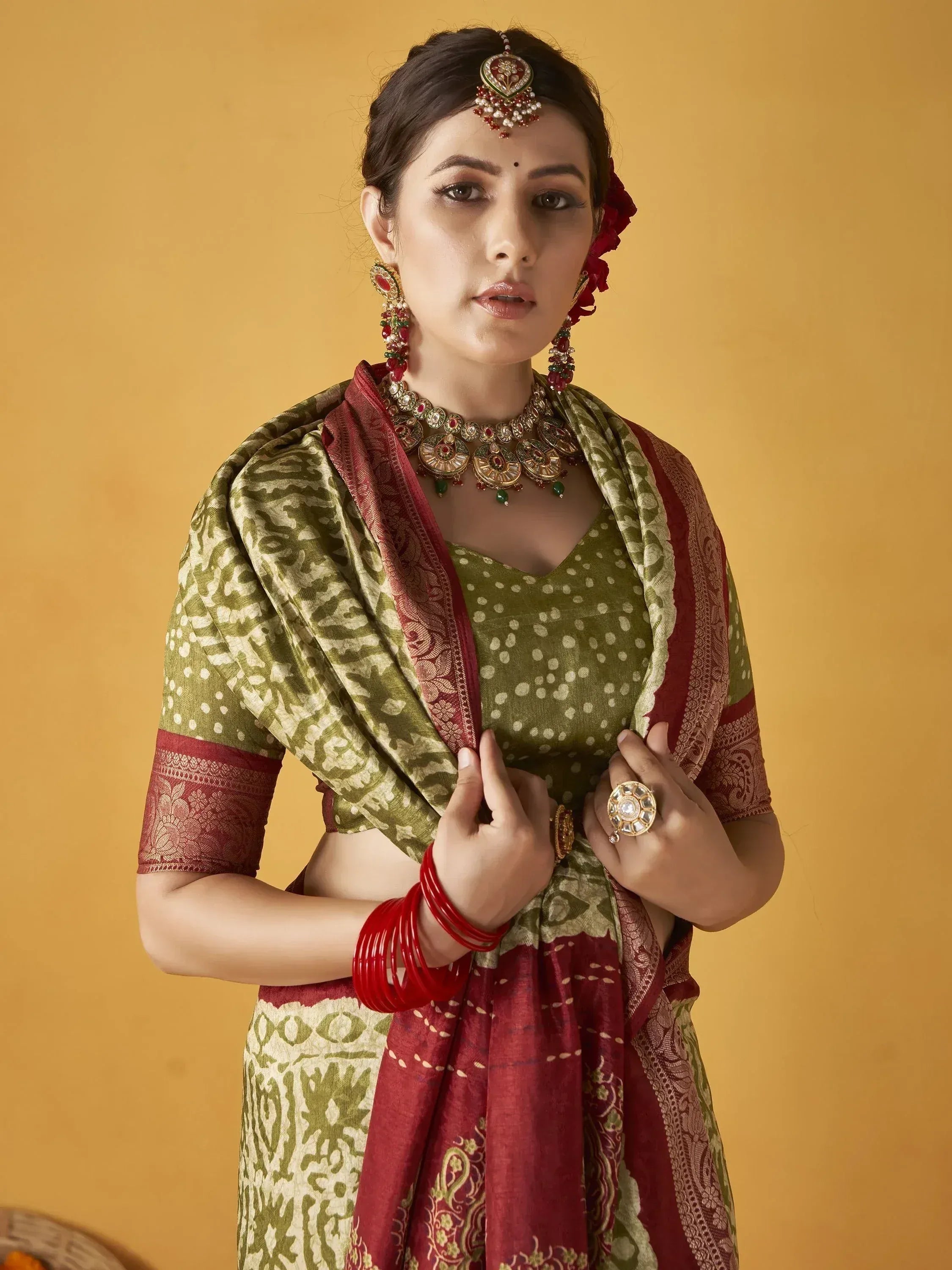 Woman in olive green and maroon ethnic saree with traditional jewelry, perfect for Indian festivals and weddings.