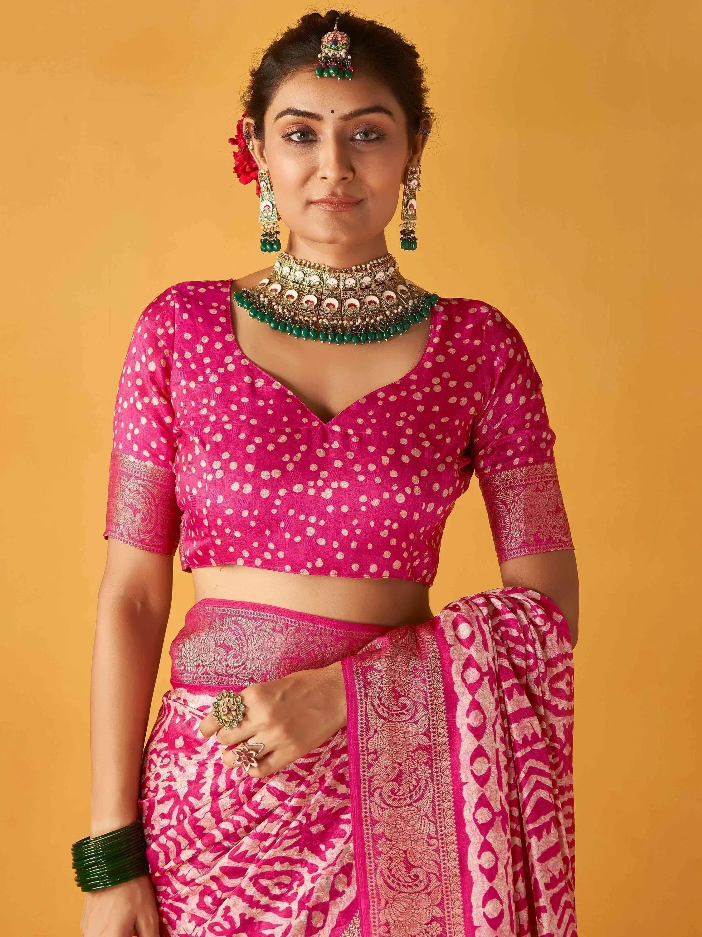 Woman in pink polka dot blouse and printed saree with traditional jewelry, Indian ethnic wear