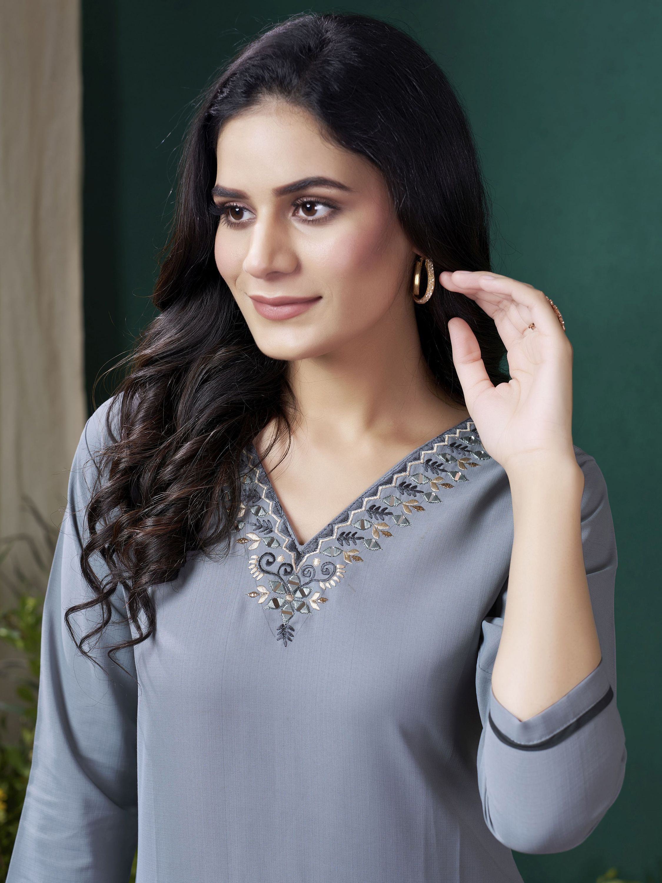 Woman wearing a grey ethnic kurti with embroidered V-neck and hoop earrings