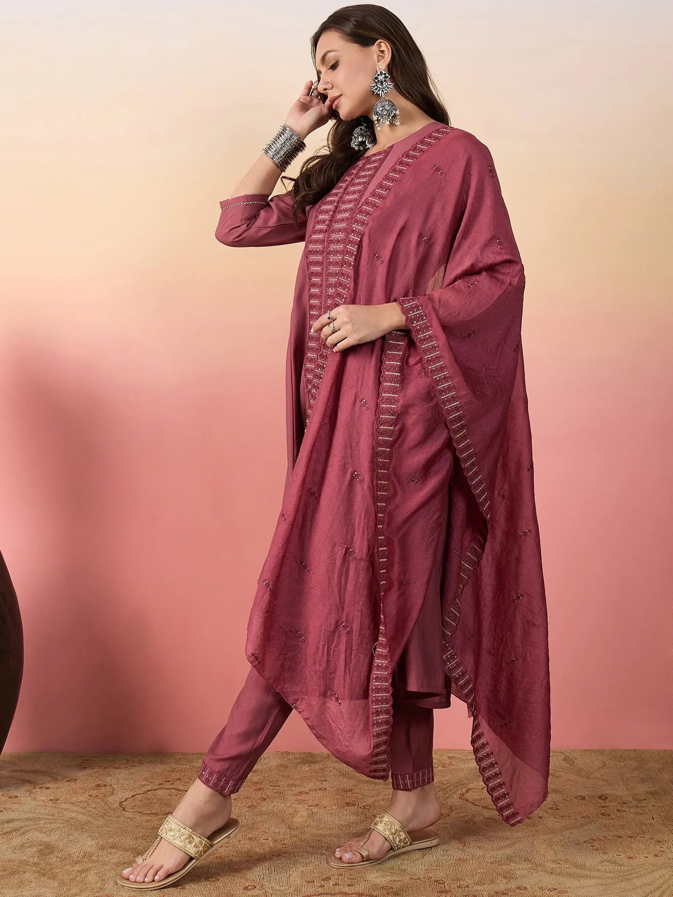 Elegant maroon ethnic salwar kameez with detailed embroidery and matching dupatta, styled with statement jewelry.