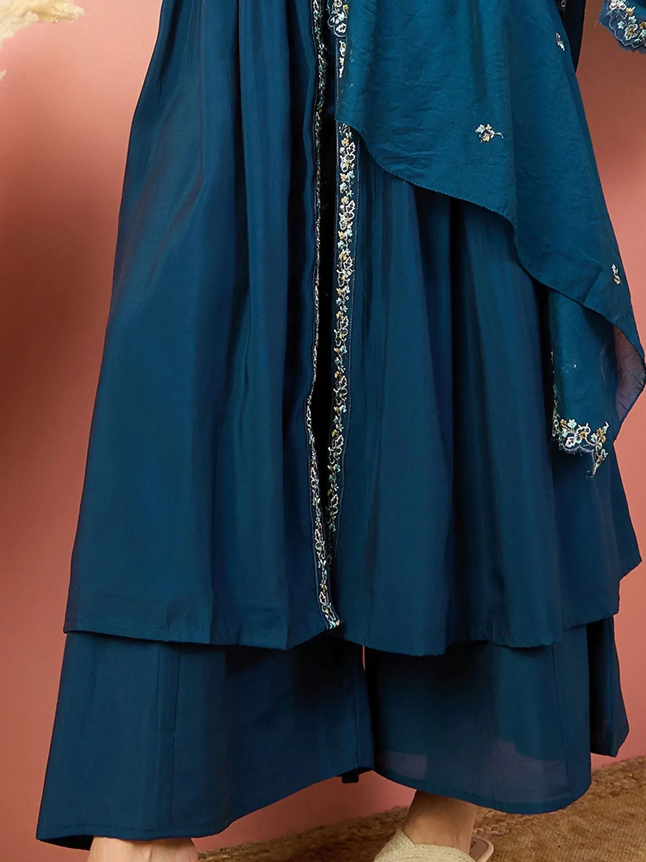 Teal blue embroidered ethnic gown with layered skirt and floral detailing, perfect for Indian occasions.