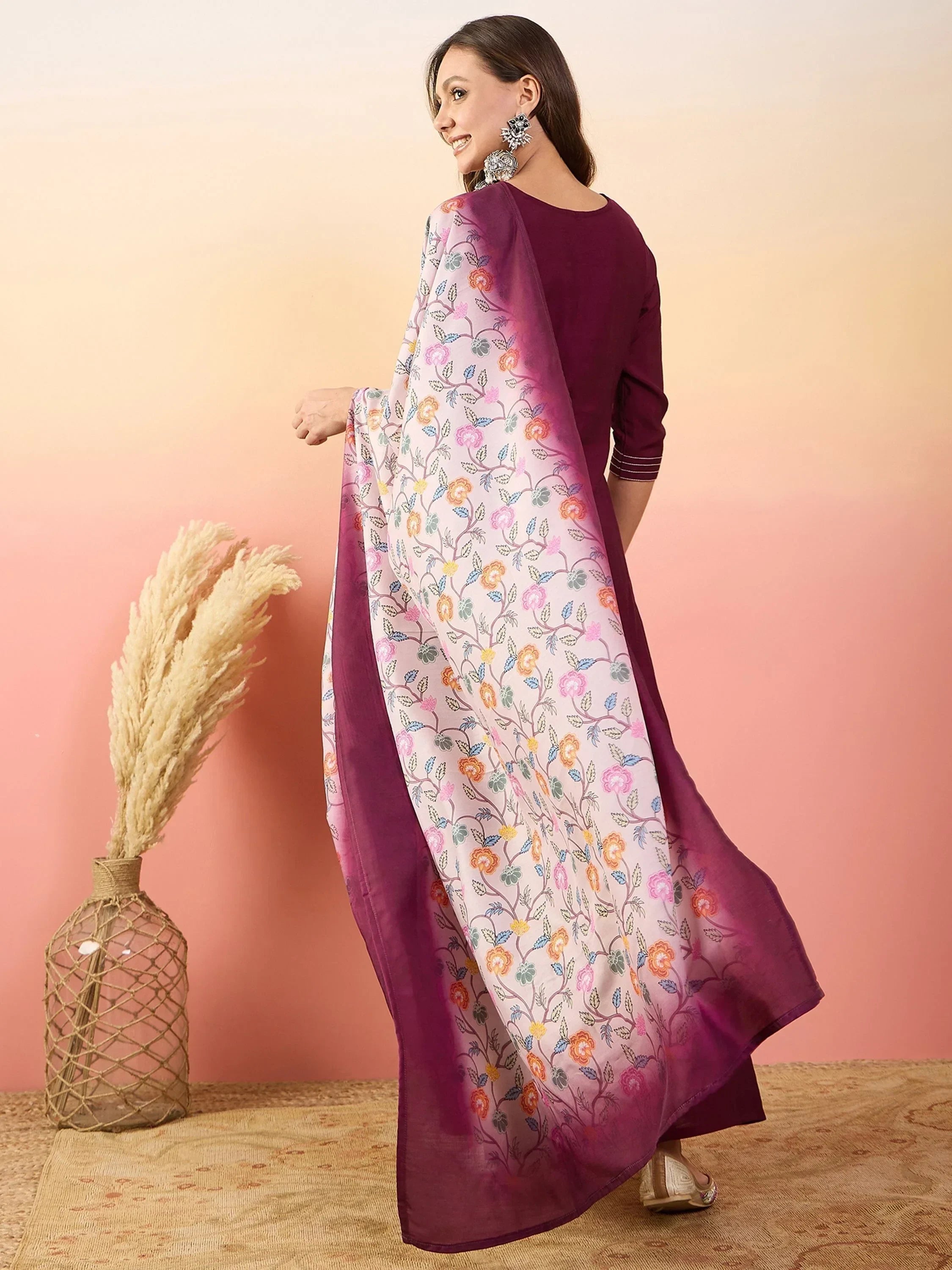 Woman in maroon ethnic kurta with floral printed dupatta, statement earrings, indoor setting
