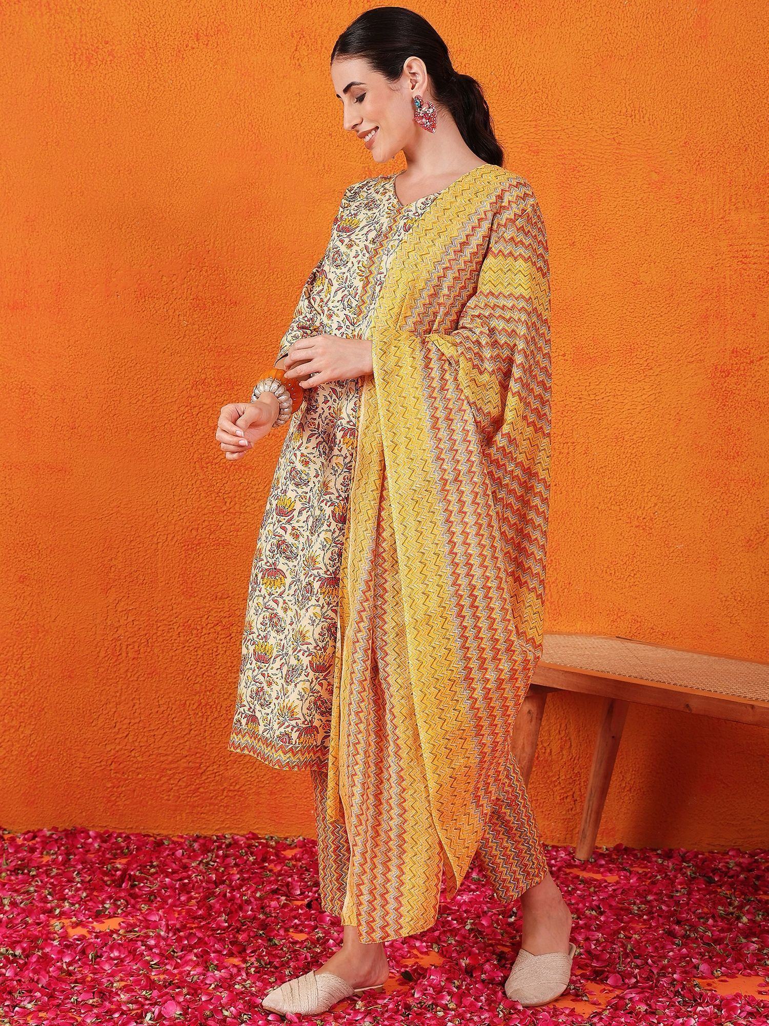 Woman in printed yellow and floral ethnic salwar kameez with dupatta, standing on rose petals