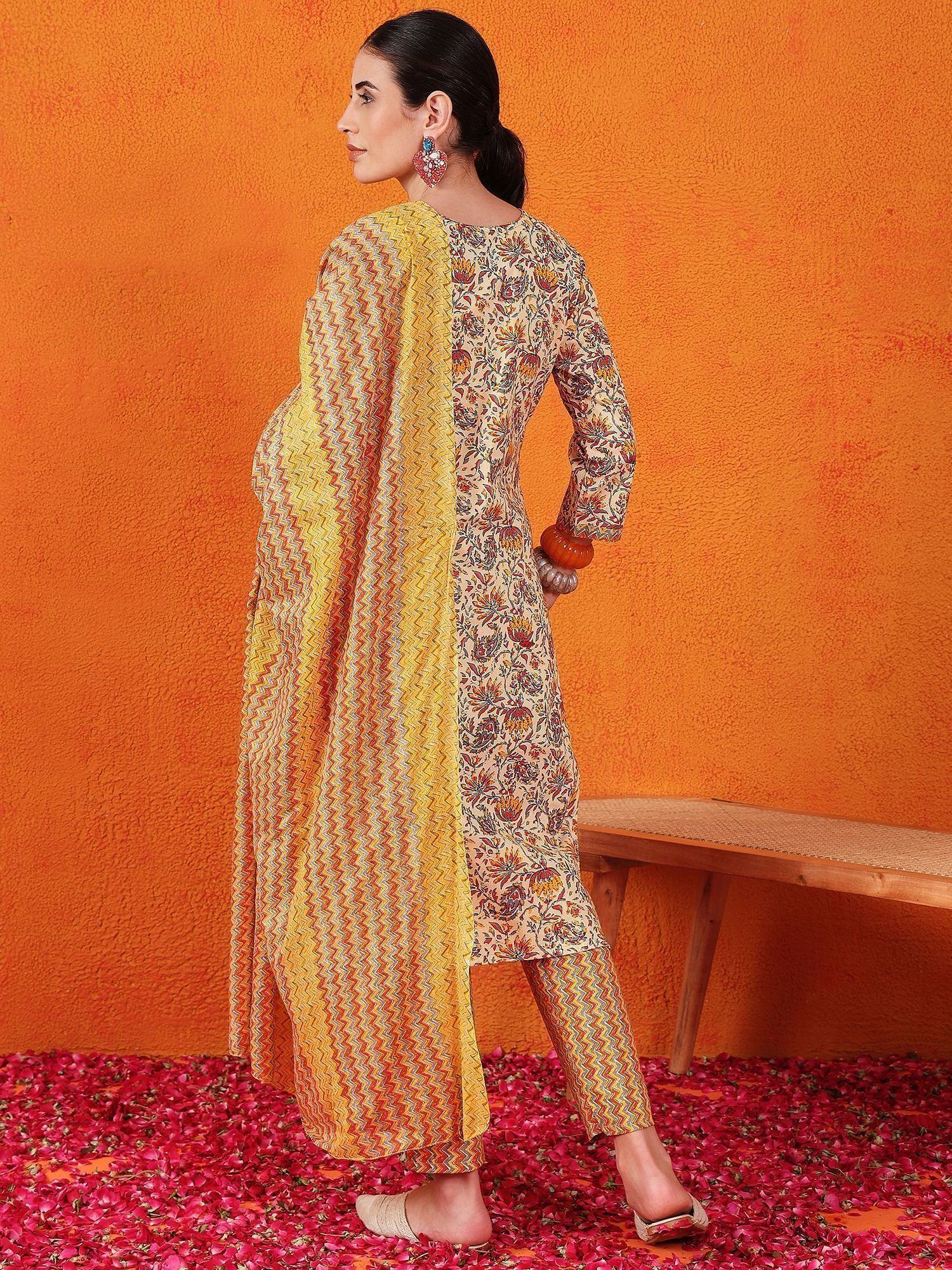 Woman wearing floral printed salwar kameez with yellow dupatta, standing on rose petals