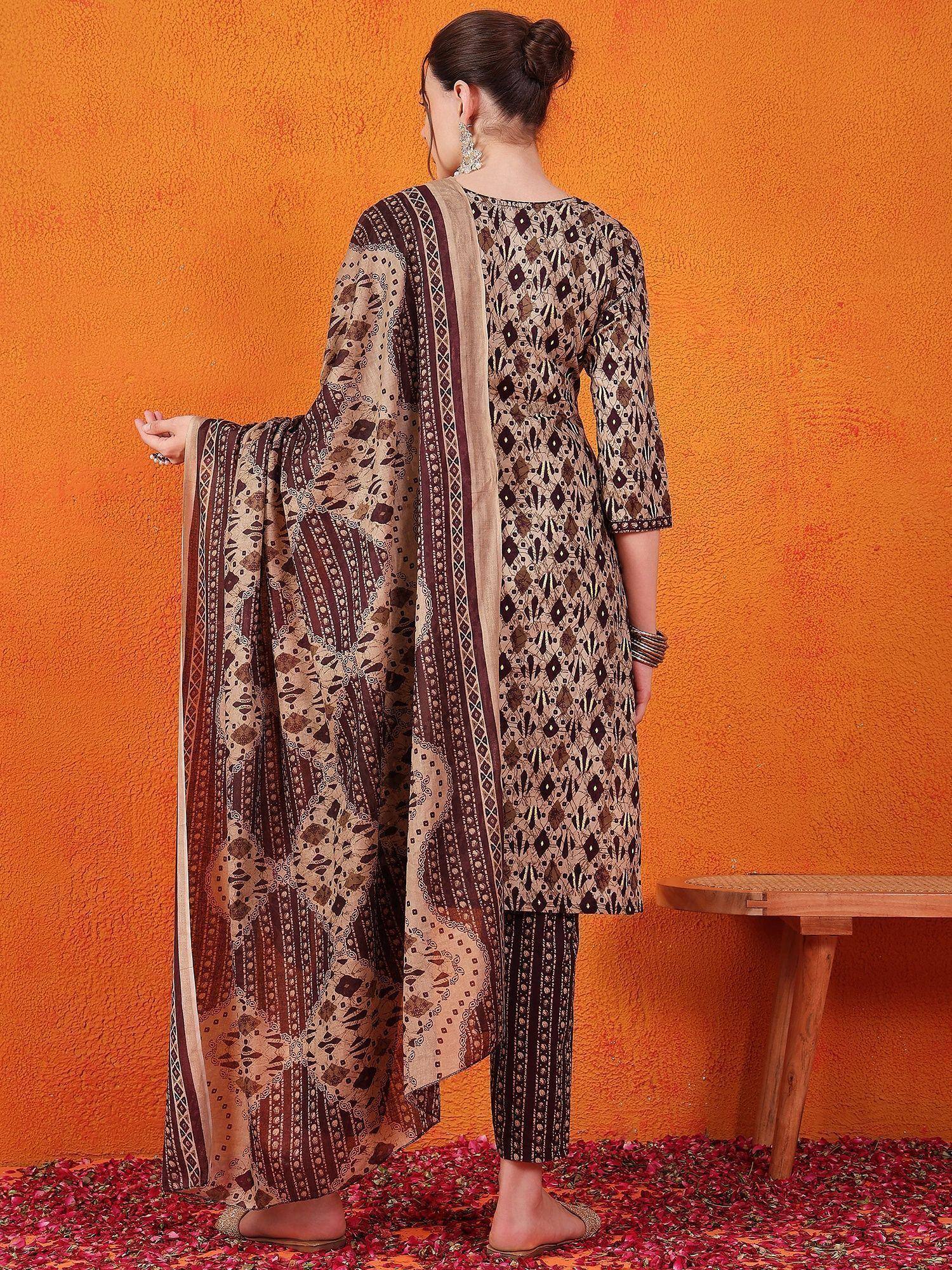 Woman in printed ethnic salwar kameez with dupatta, back view against orange wall
