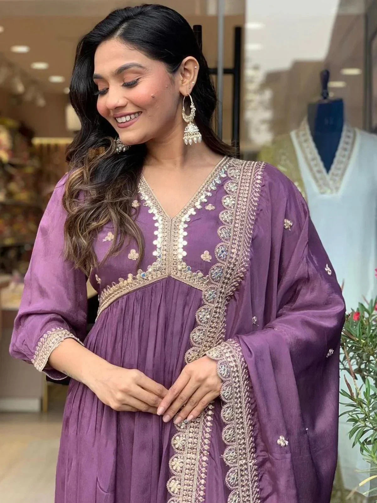 Woman in purple embroidered ethnic gown with dupatta, traditional Indian earrings
