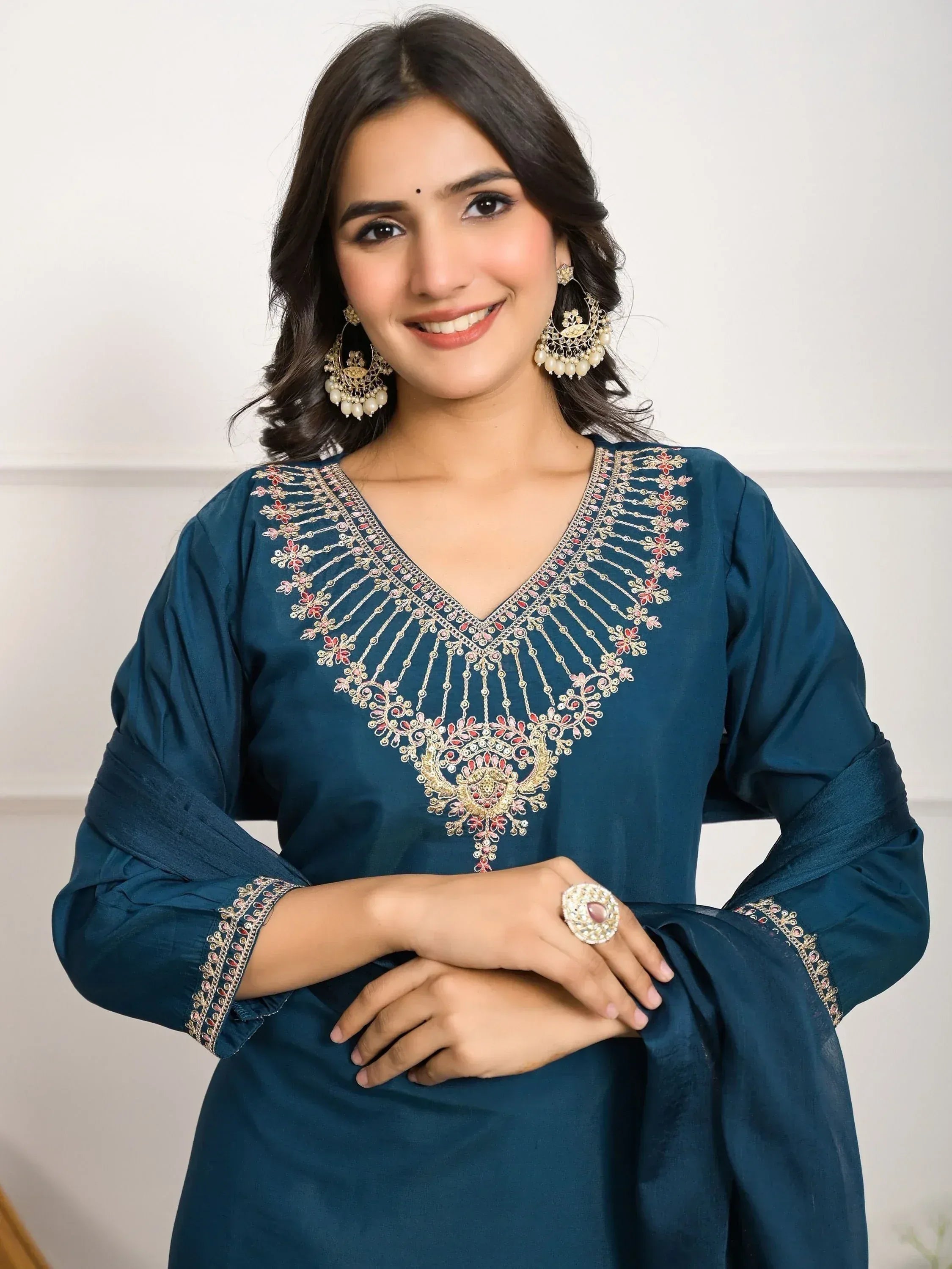 Teal ethnic kurti with floral embroidery, gold detailing, and statement earrings for festive occasions