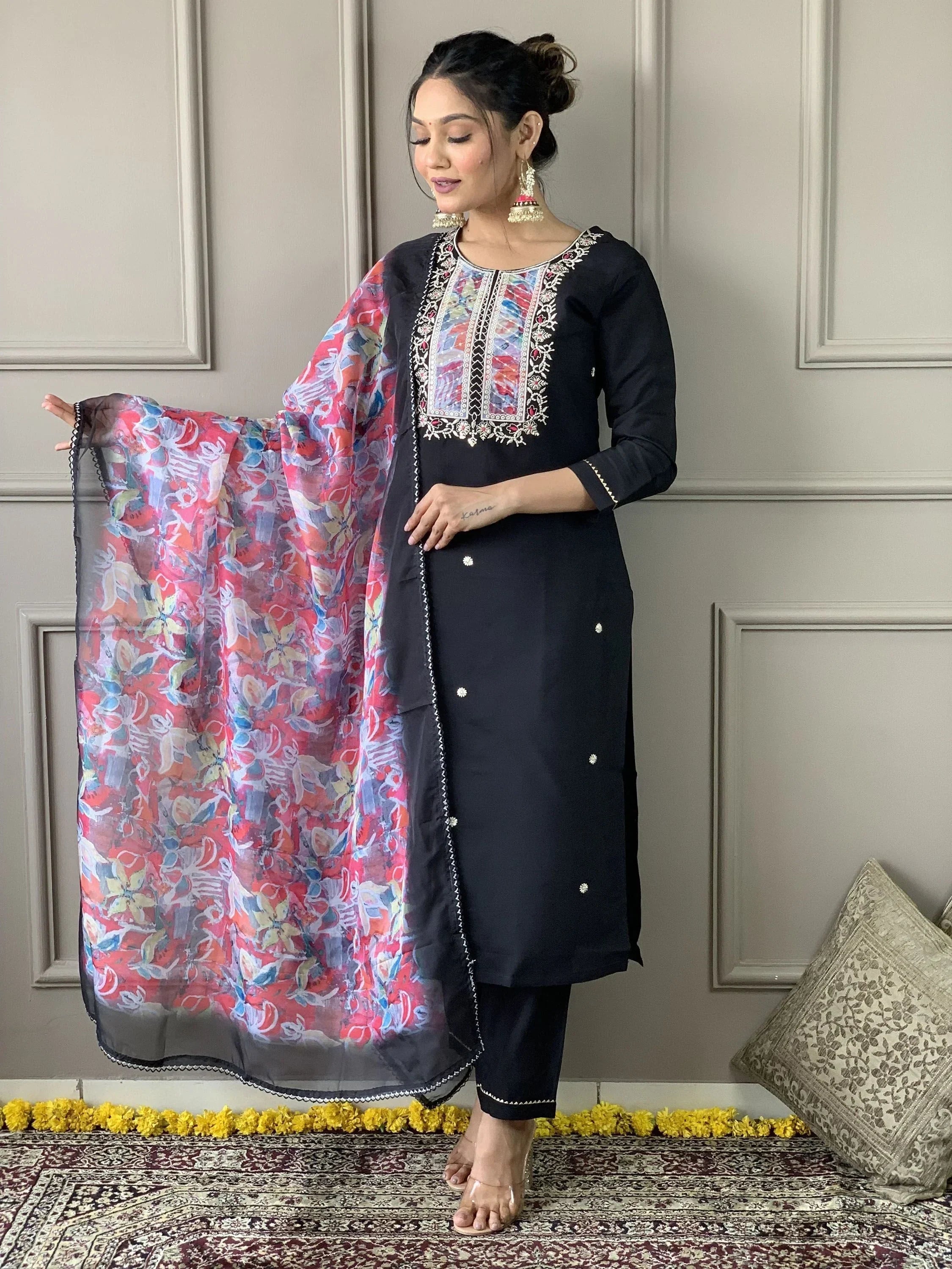 Woman in black embroidered salwar kameez with colorful dupatta, traditional Indian wear