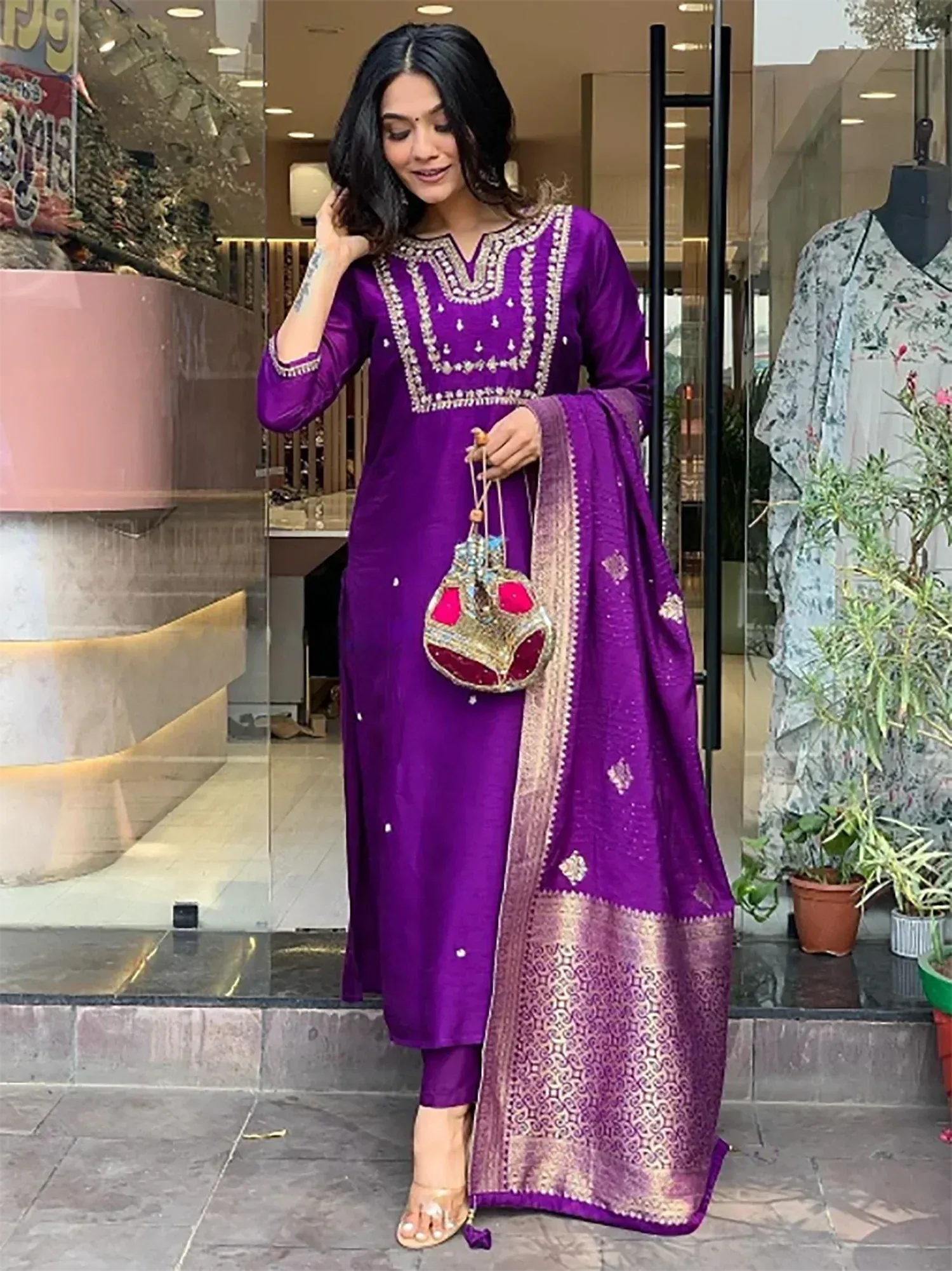 Purple embroidered salwar kameez with gold dupatta and embellished handbag
