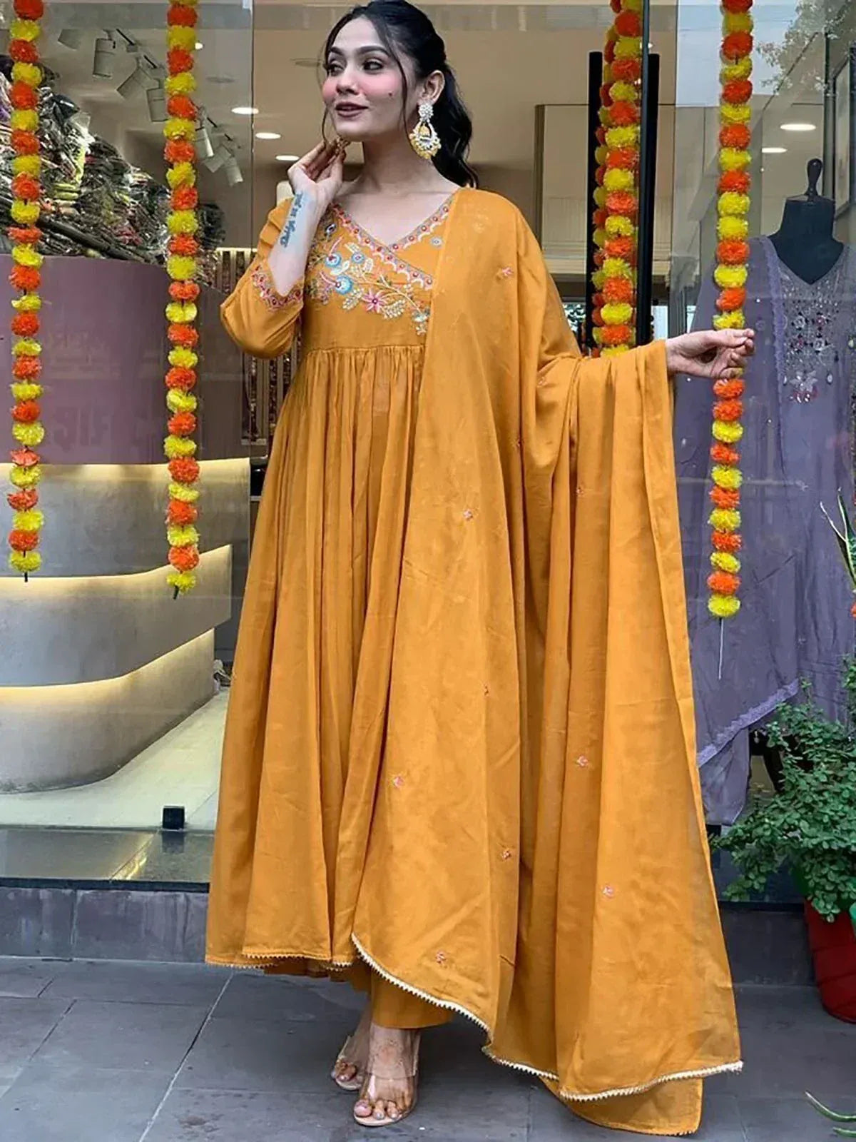 Mustard yellow embroidered ethnic gown with flared sleeves, perfect for Indian festive occasions