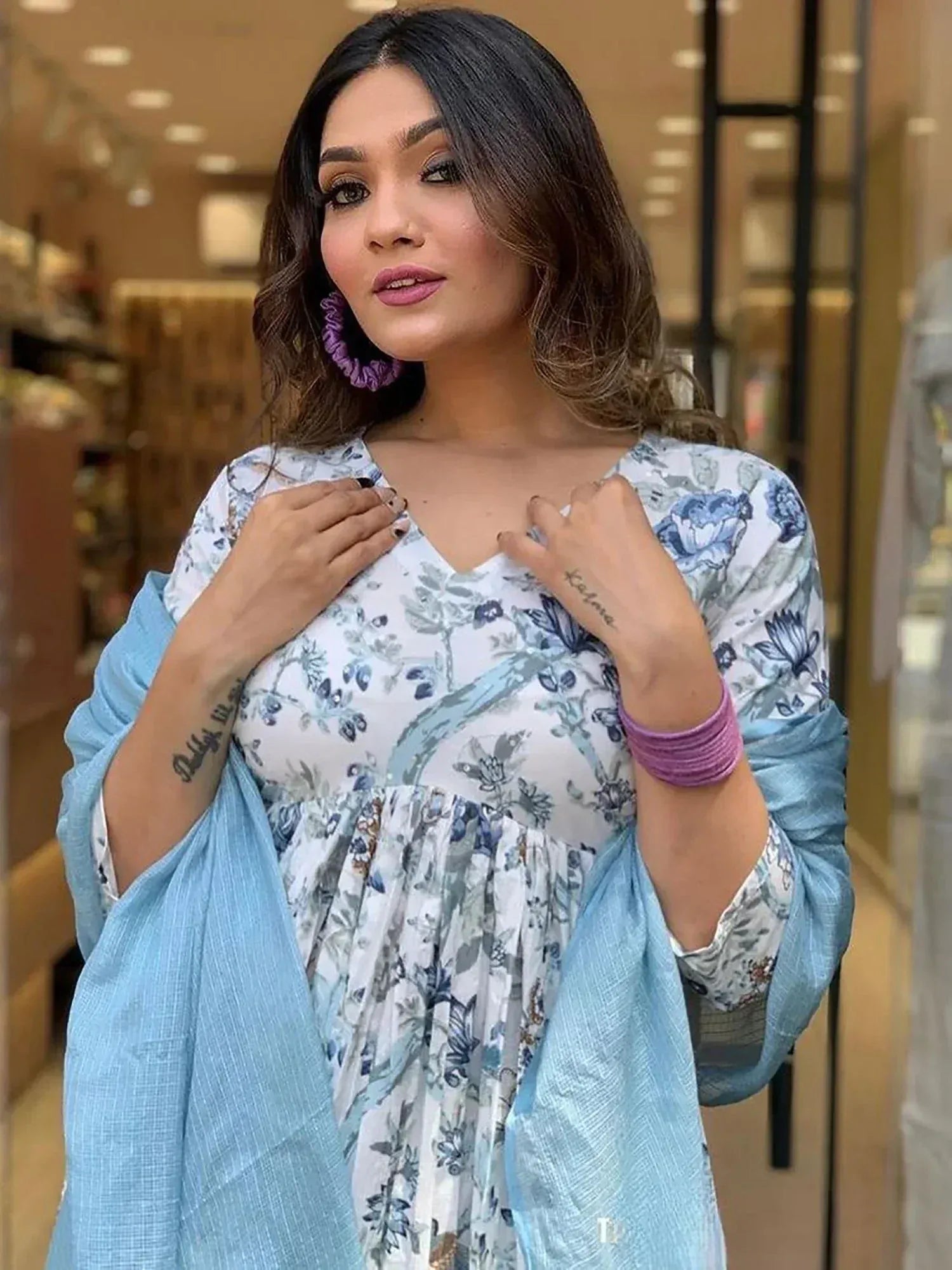 Woman in floral print ethnic gown with blue dupatta, styled for Indian occasions