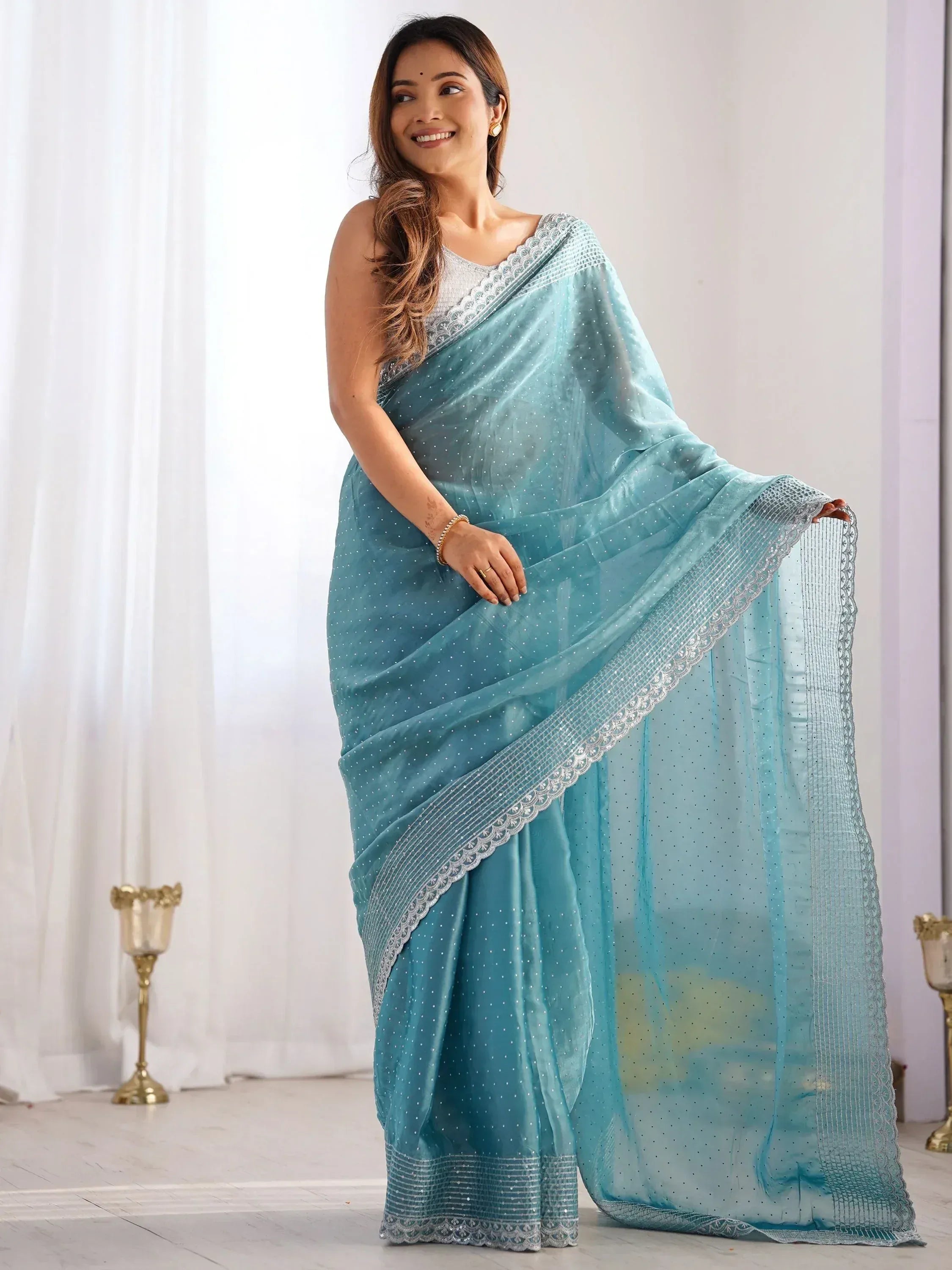 Woman in elegant light blue saree with silver embroidery, perfect for Indian ethnic wear occasions.