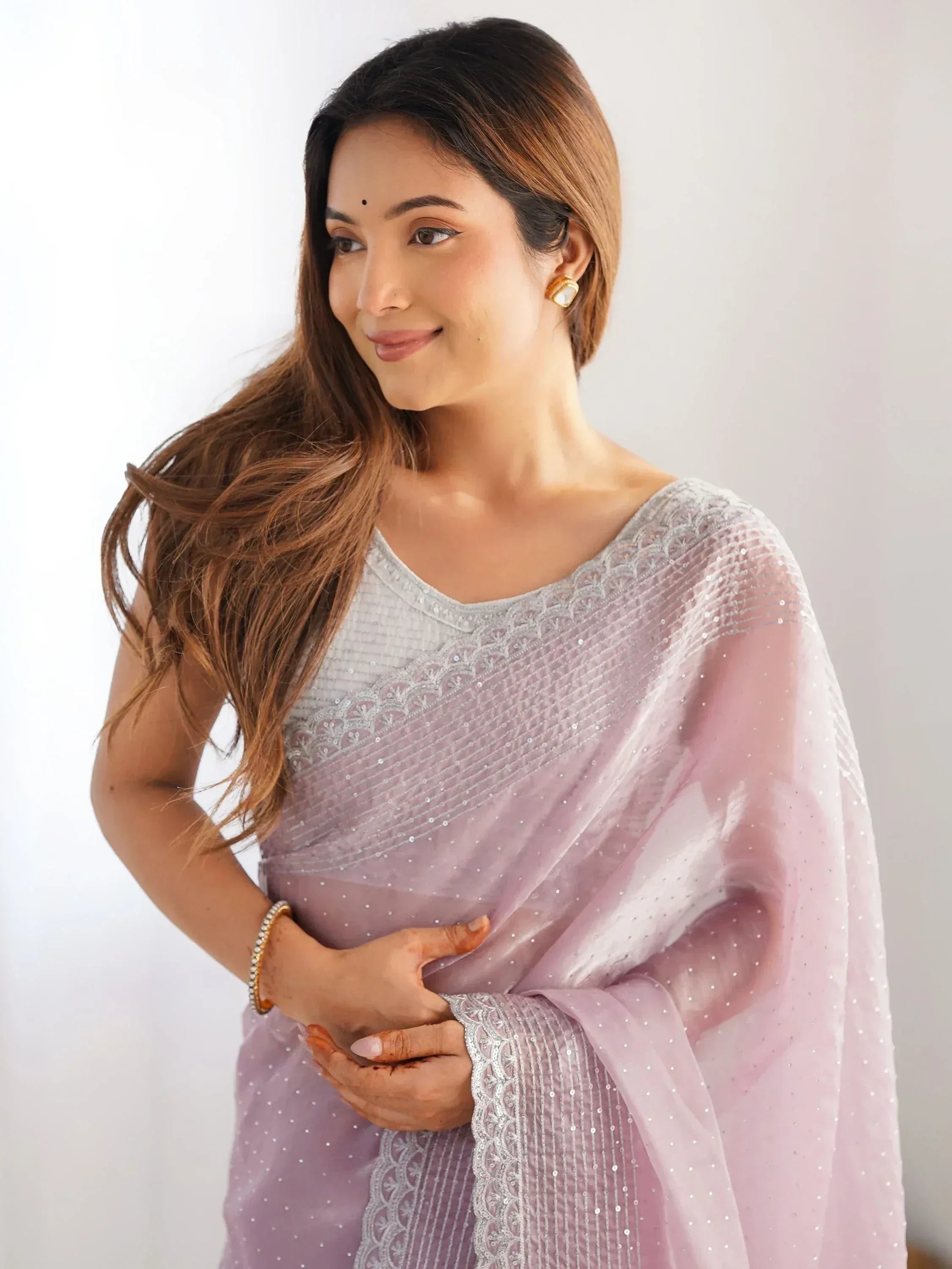 Woman in lavender ethnic saree with silver embroidery and sequins, styled for Indian occasions