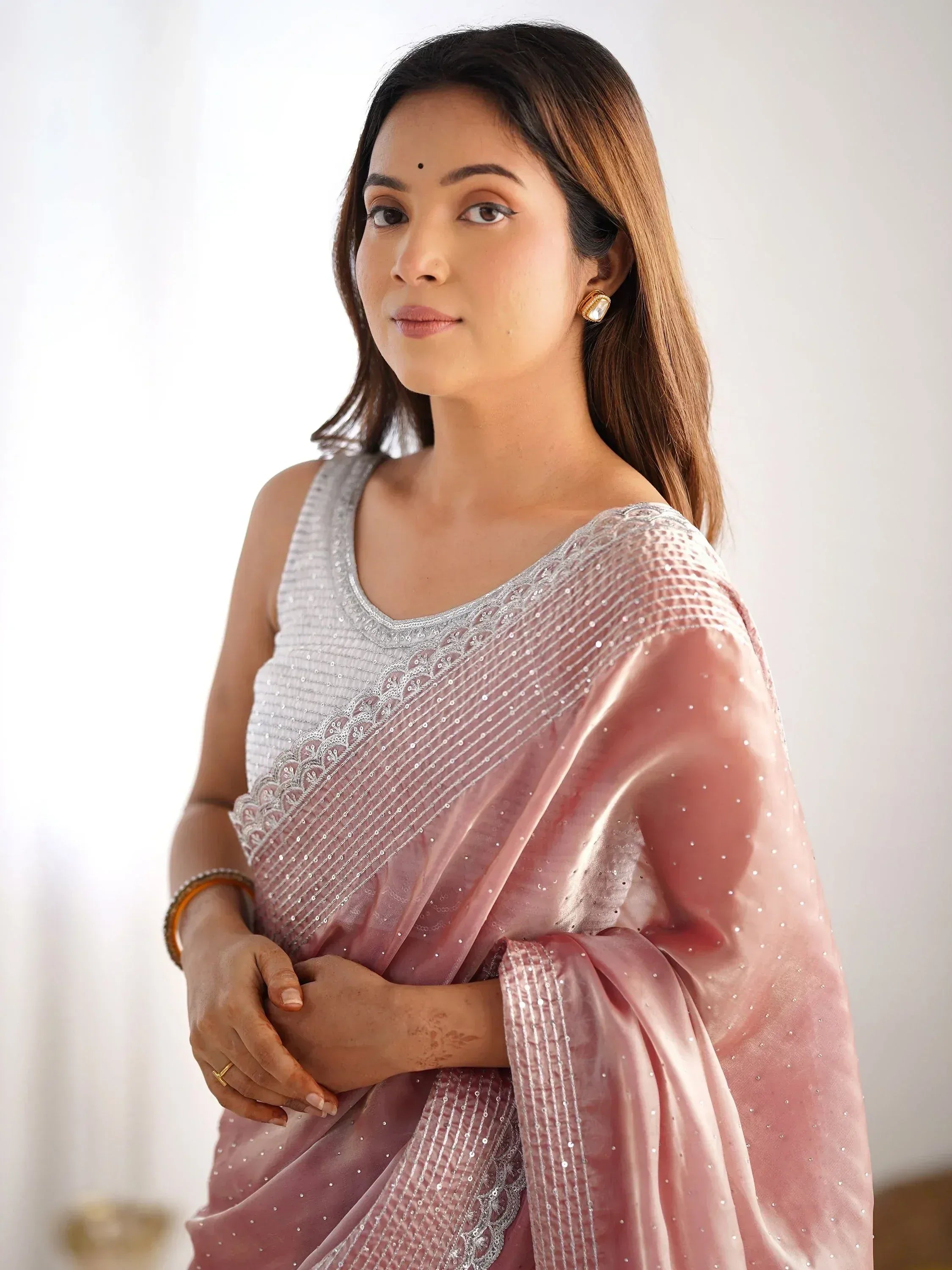 Woman in elegant pink saree with silver embellishments, perfect for Indian ethnic wear occasions