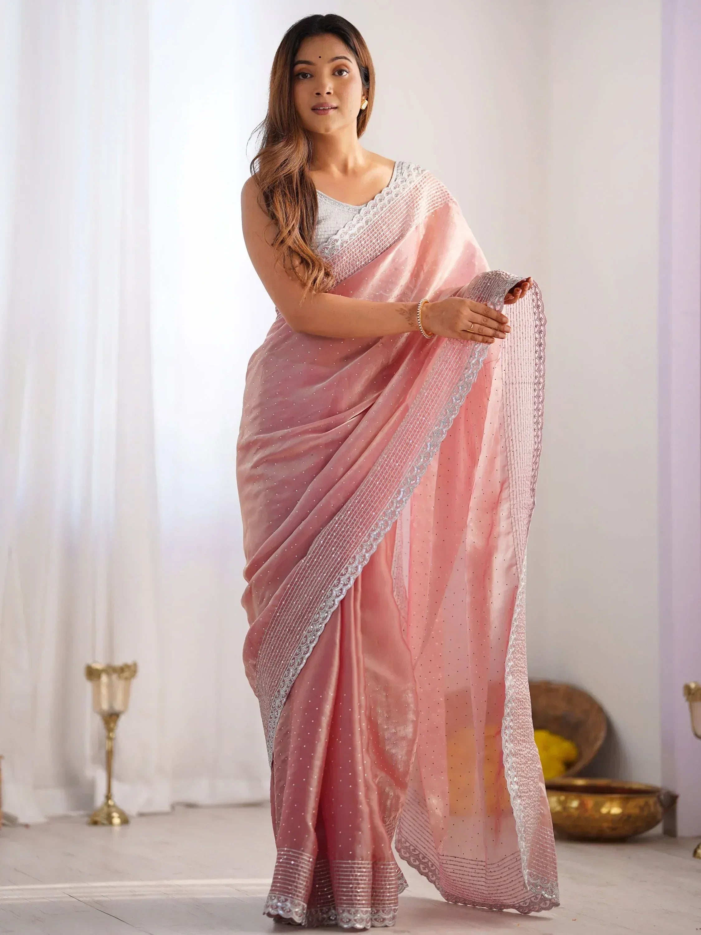 Pink ethnic saree with silver embroidery and sequins, paired with matching blouse for festive occasions