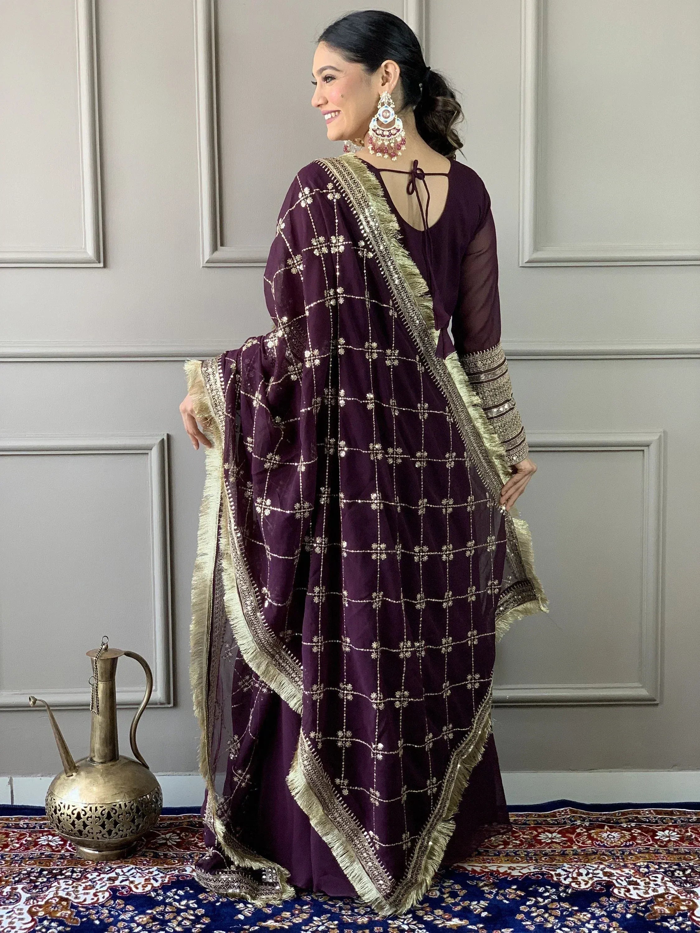 Elegant purple ethnic salwar kameez with gold embroidery and fringe, styled with traditional jewelry