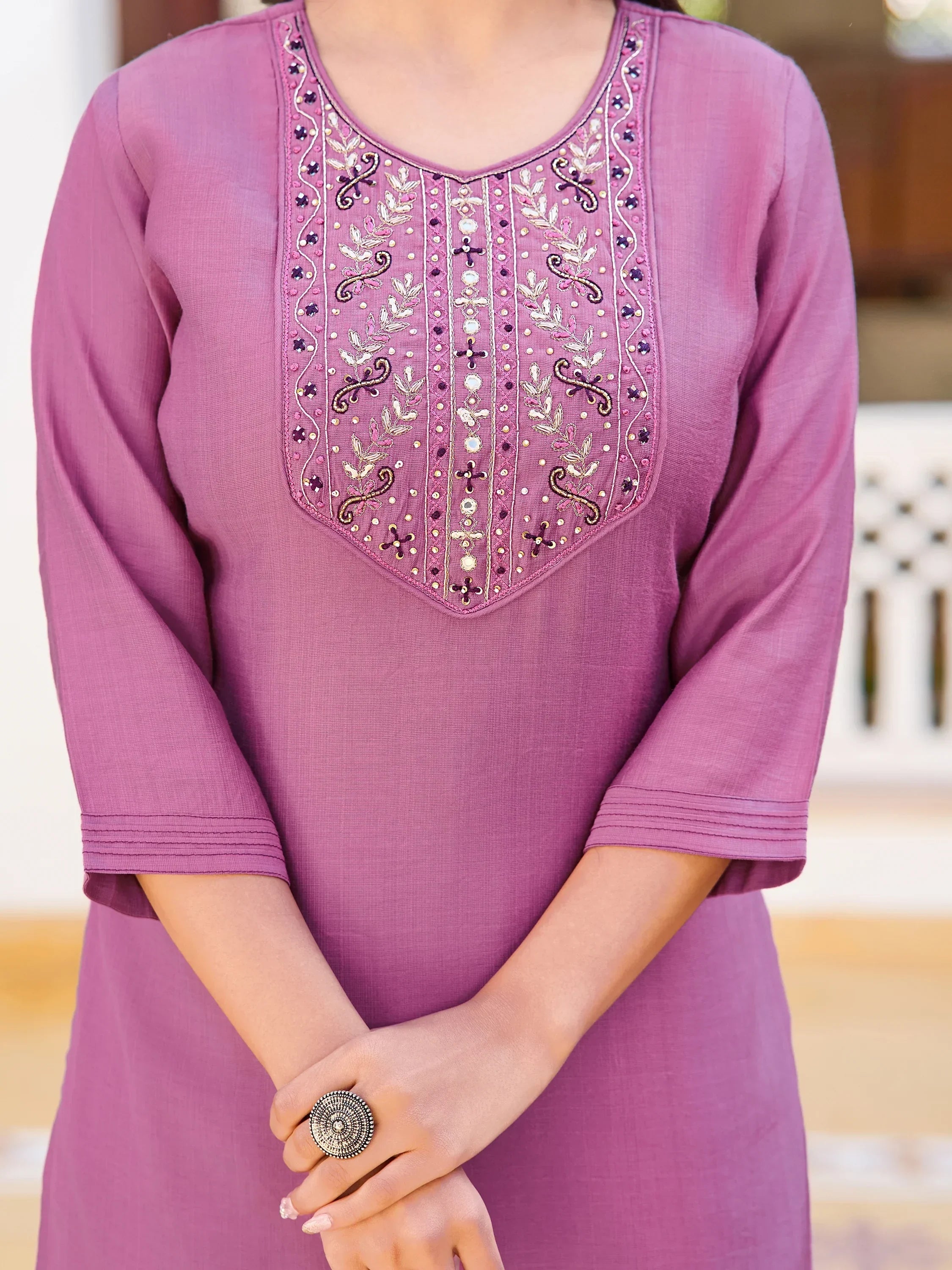 Woman in mauve kurti with intricate embroidered yoke and three-quarter sleeves