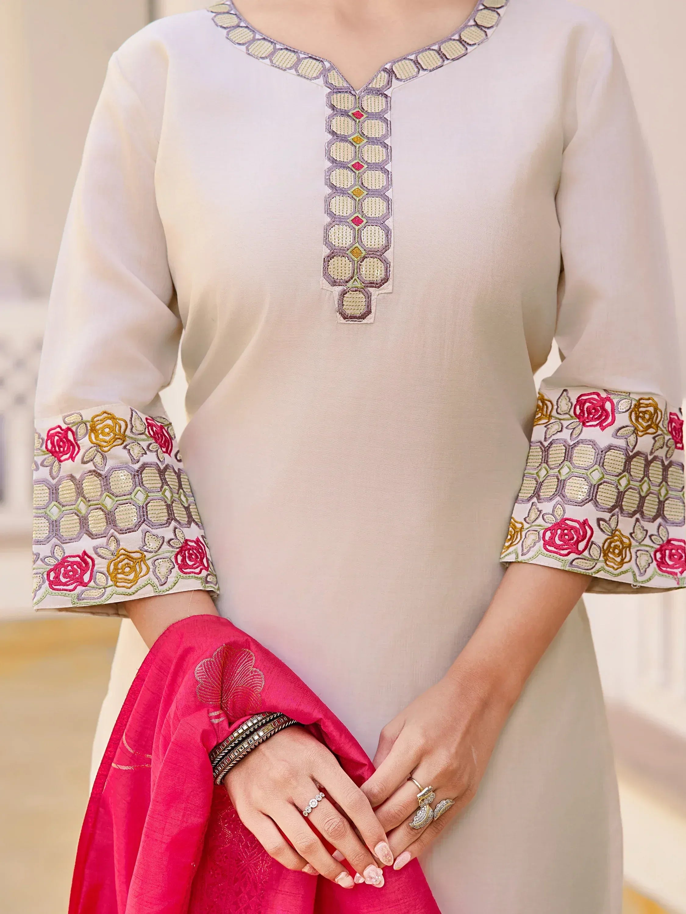 Cream ethnic kurti with floral embroidery on sleeves and neckline, paired with pink dupatta