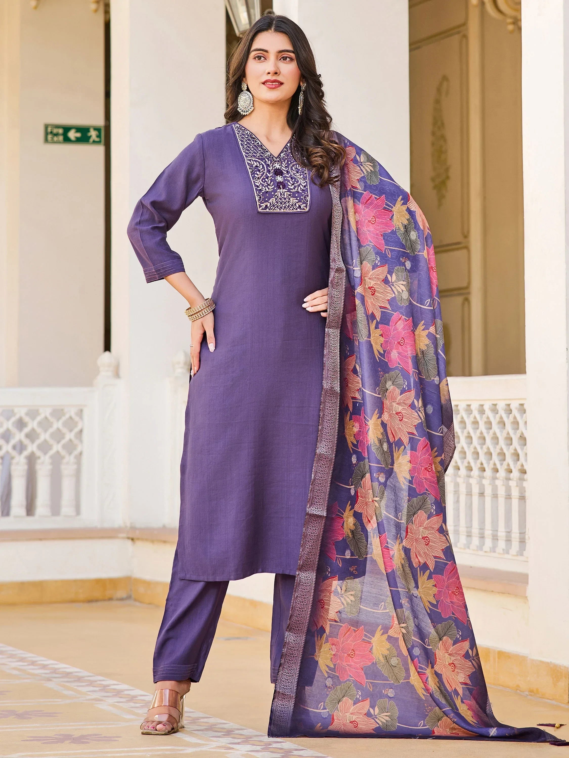 Woman wearing purple salwar kameez with floral printed dupatta and embroidered neckline