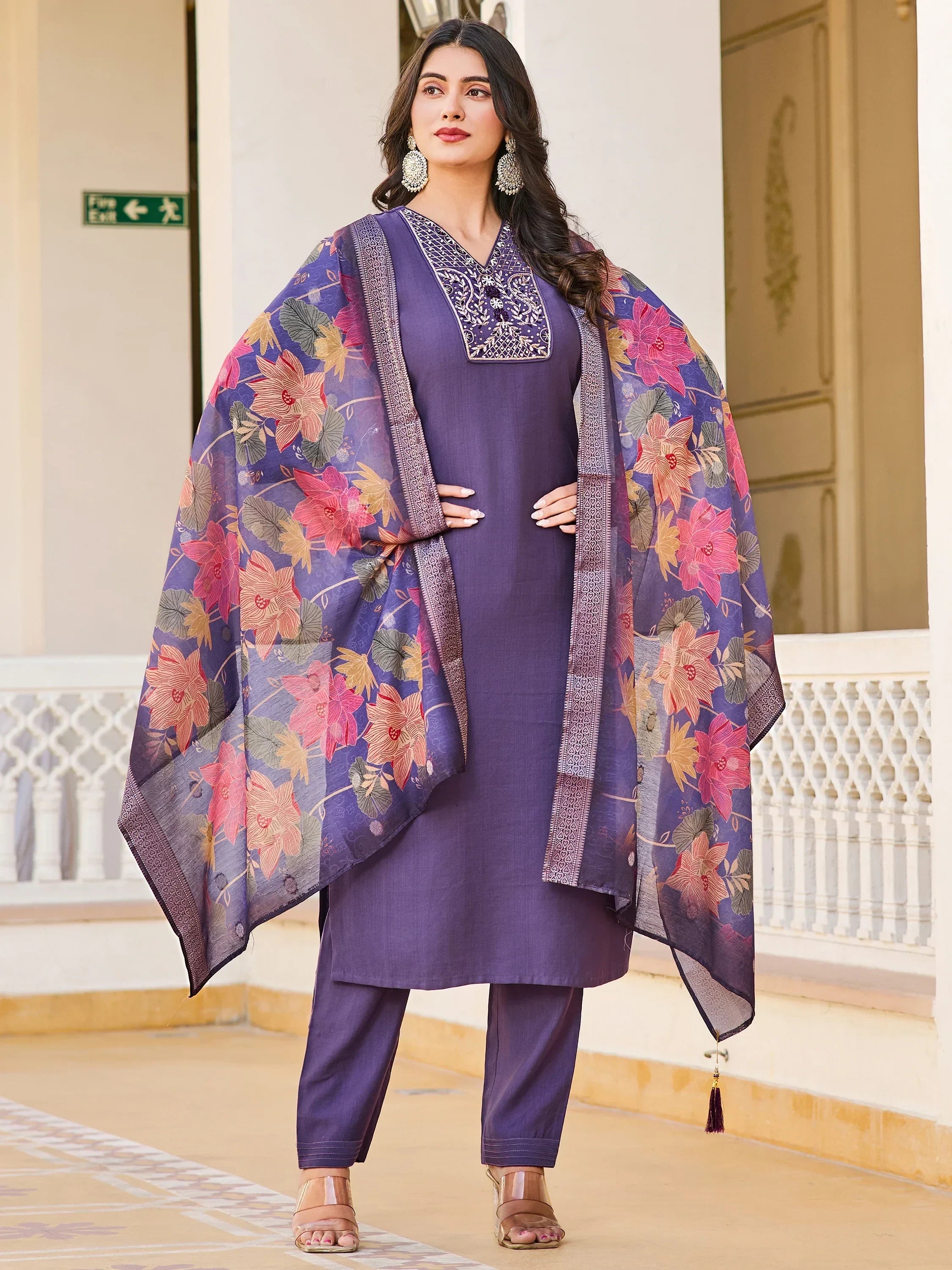 Woman in purple embroidered salwar kameez with floral dupatta and statement earrings