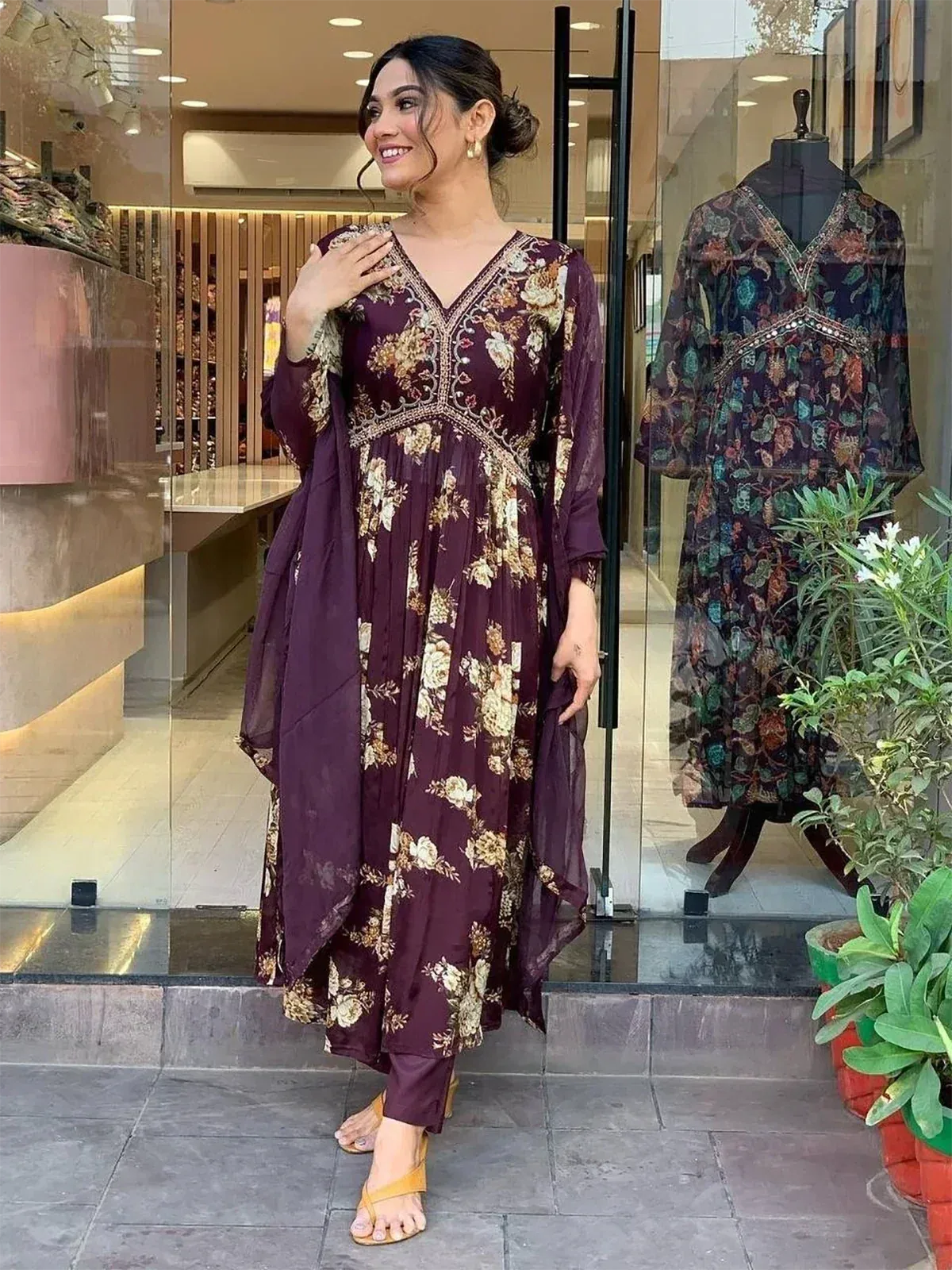 Woman in maroon floral ethnic gown with embroidery, perfect for Indian occasions and festive wear.