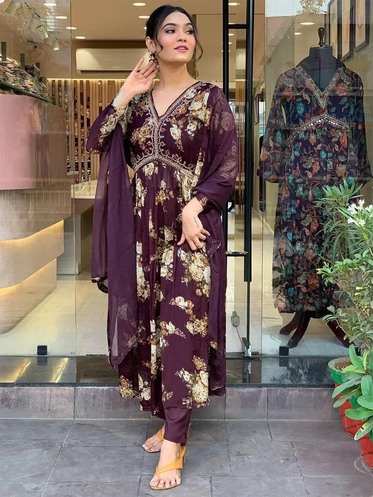 Woman in purple floral ethnic gown with matching pants and dupatta, stylish Indian wear