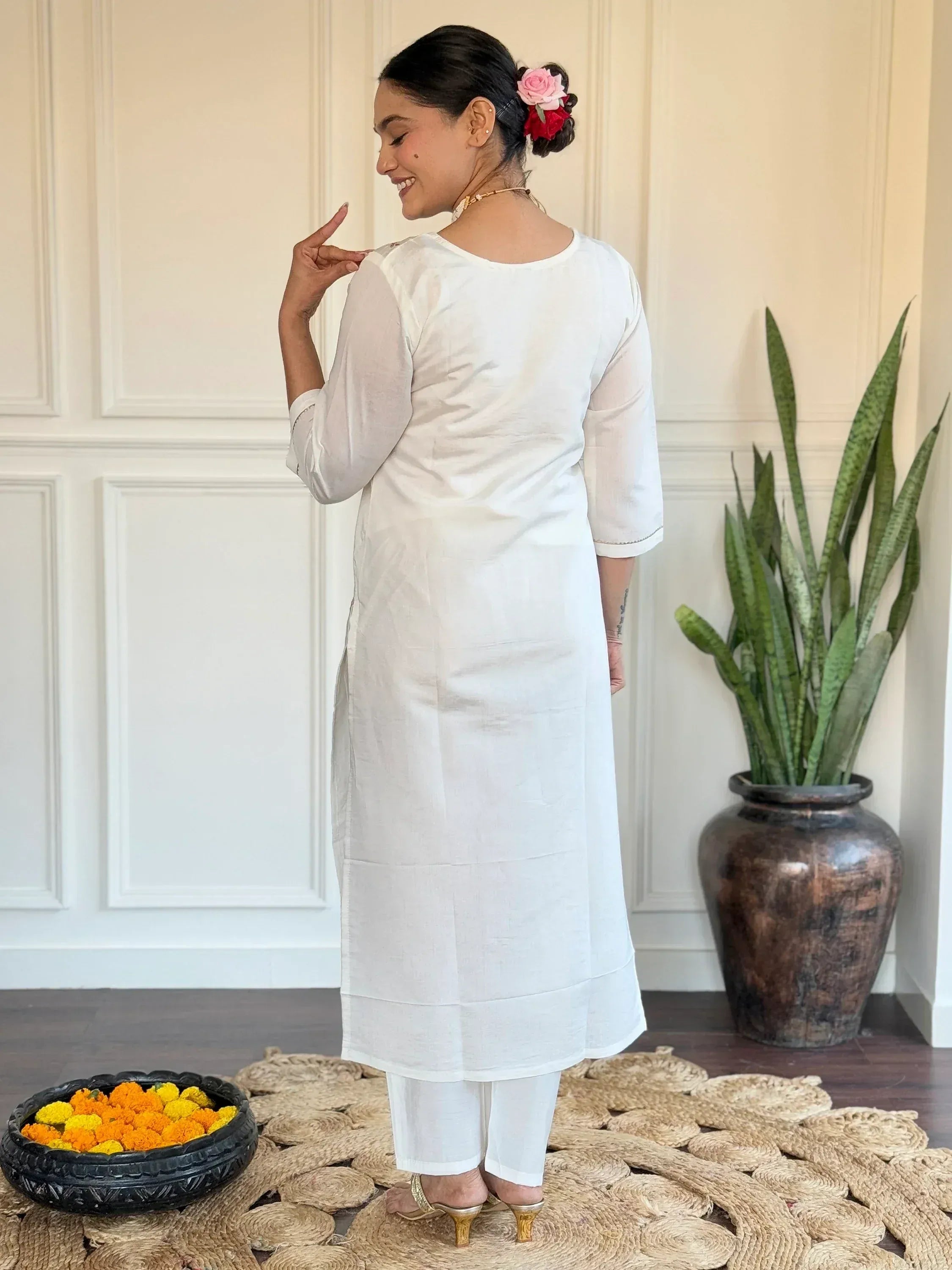 White ethnic kurta with palazzo pants, floral hair accessory, and gold heels for Indian wear