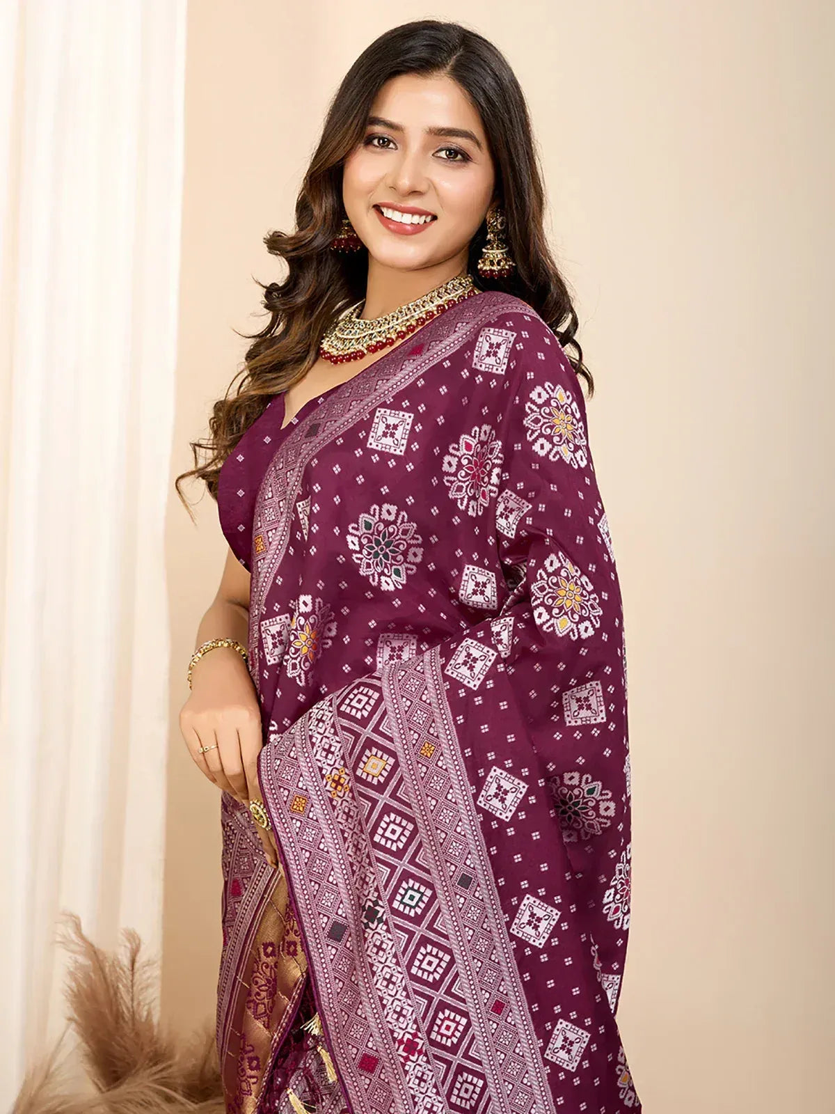 Woman in maroon printed saree with floral and geometric patterns, traditional Indian ethnic wear