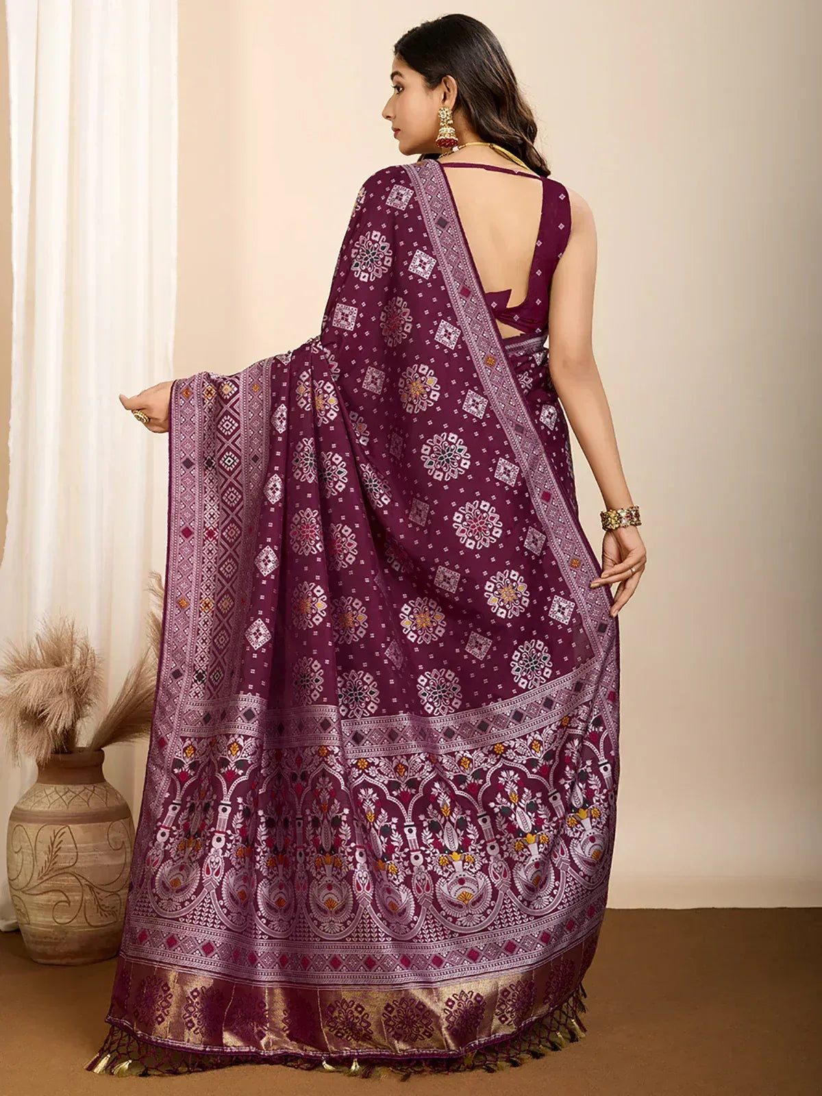 Purple printed saree with intricate floral and geometric patterns, gold border, and tassels, styled with backless blouse