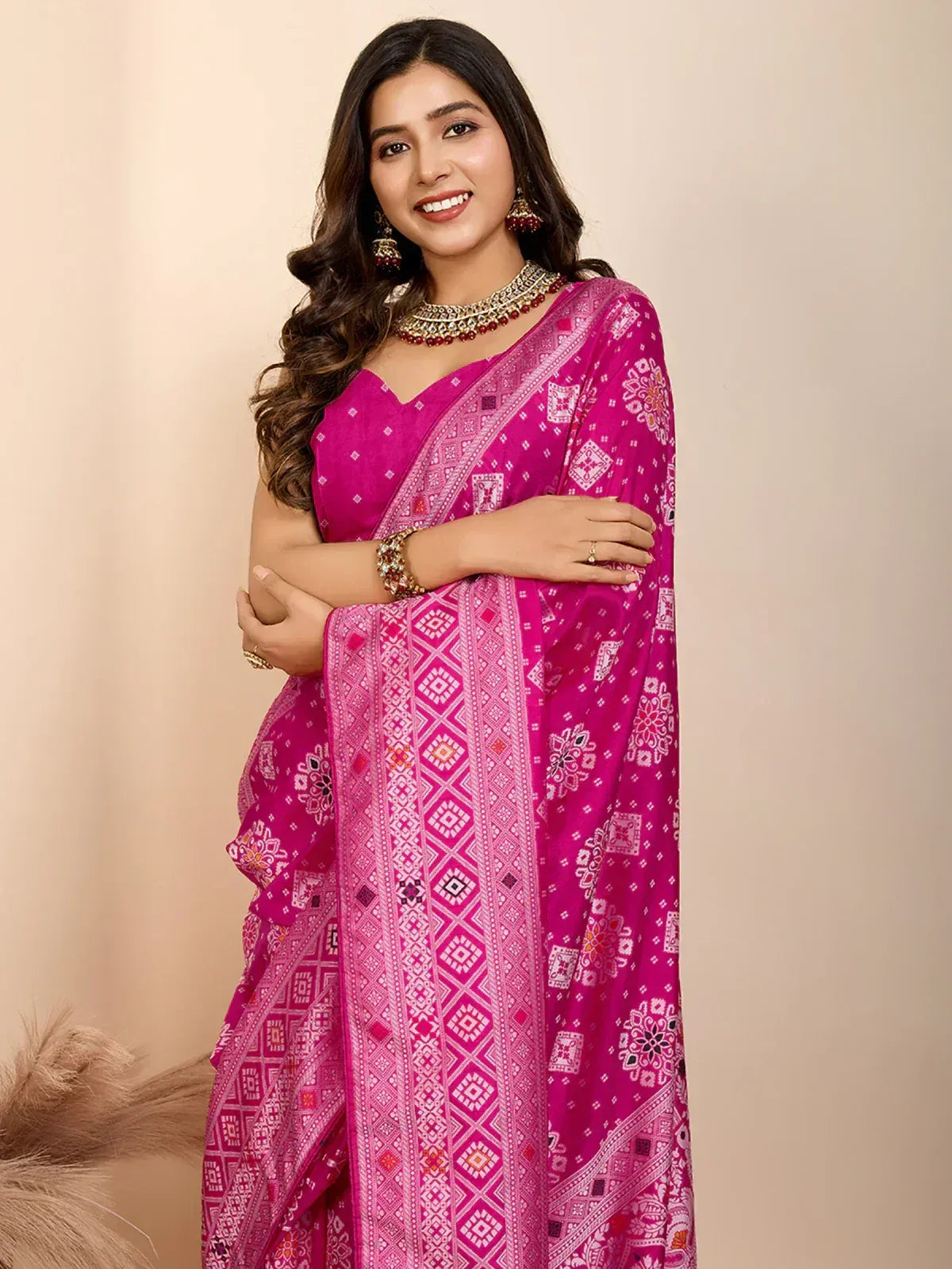 Vibrant pink printed saree with ethnic geometric patterns, paired with traditional jewelry for festive occasions