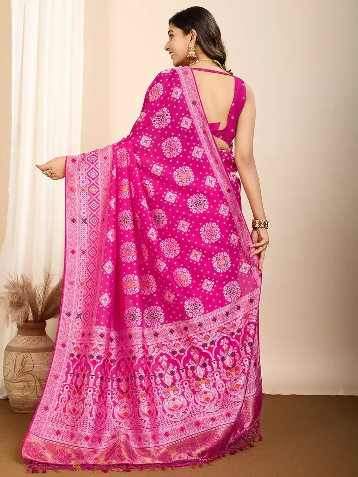 Vibrant pink printed saree with intricate floral and geometric patterns, perfect for ethnic occasions.