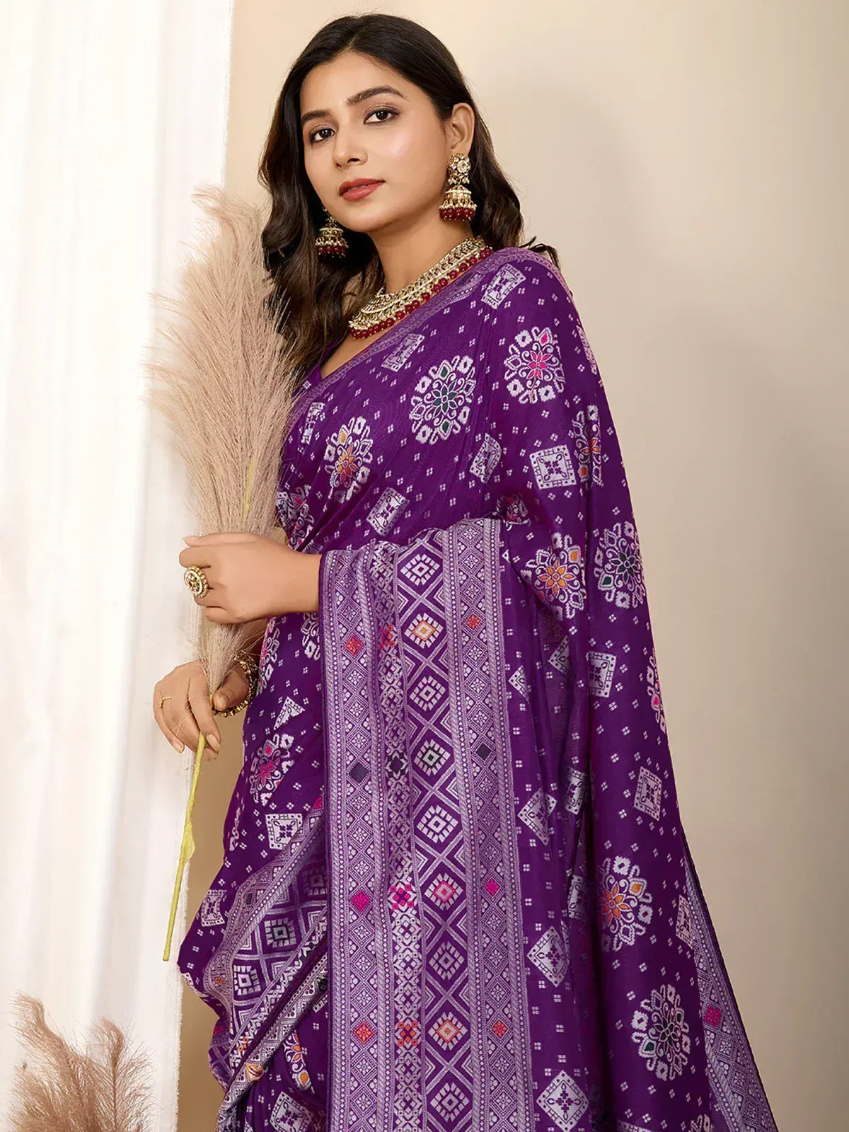 Purple printed saree with ethnic floral and geometric patterns, styled with traditional jewelry